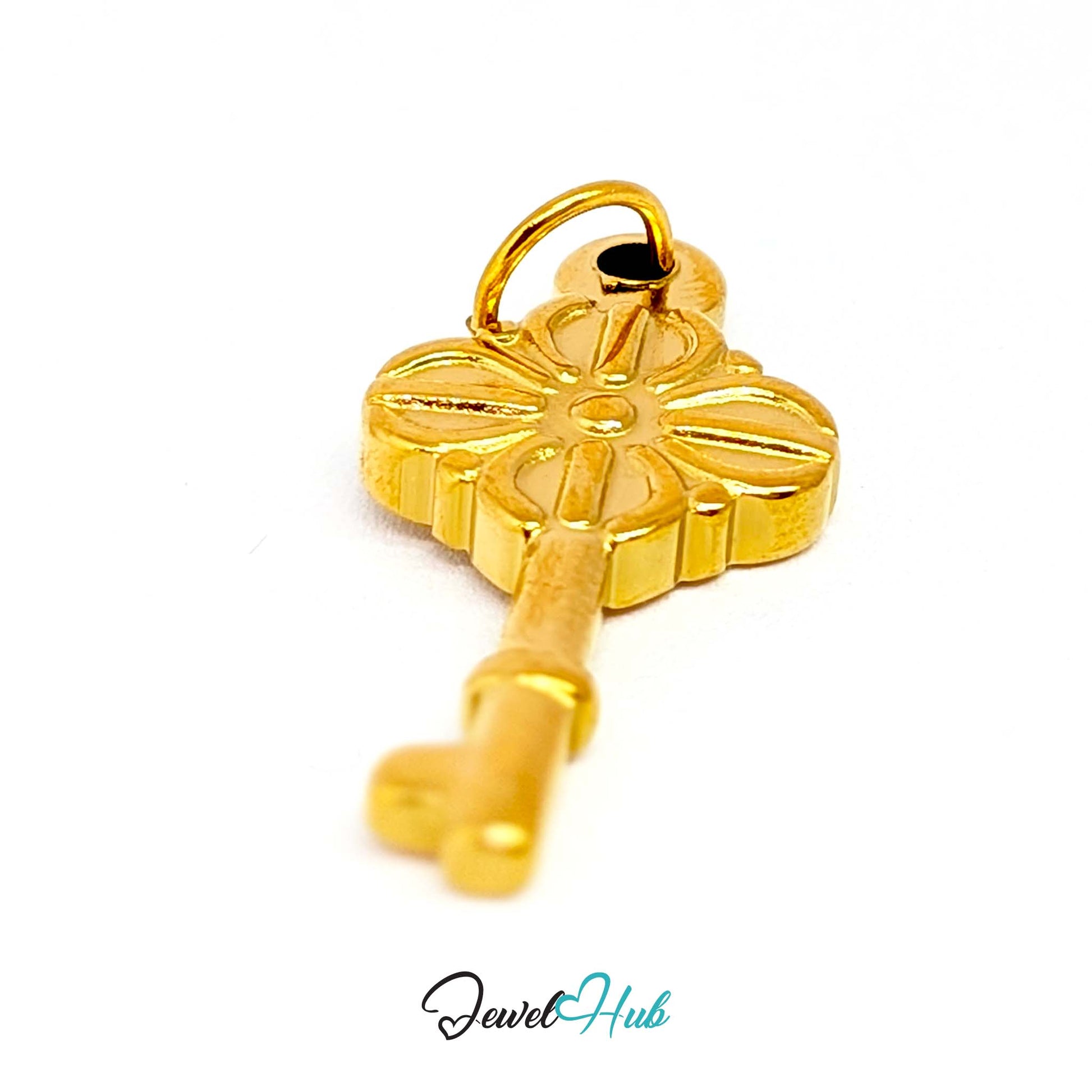 Vintage key charm in gold stainless steel with a quatrefoil bow - angled view - JewelHub