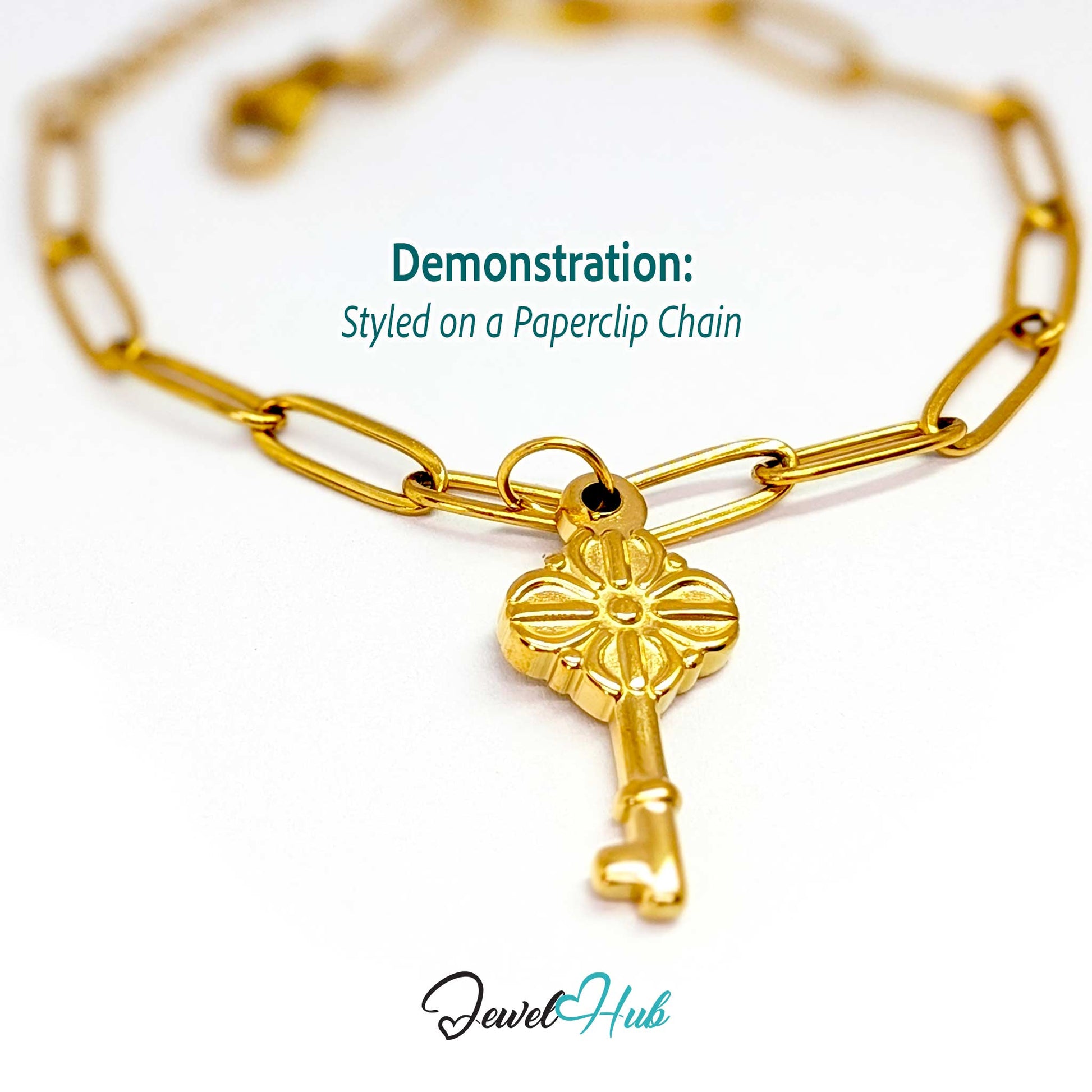 Vintage key charm in gold stainless steel with a quatrefoil bow - styled on a gold paperclip chain bracelet - JewelHub