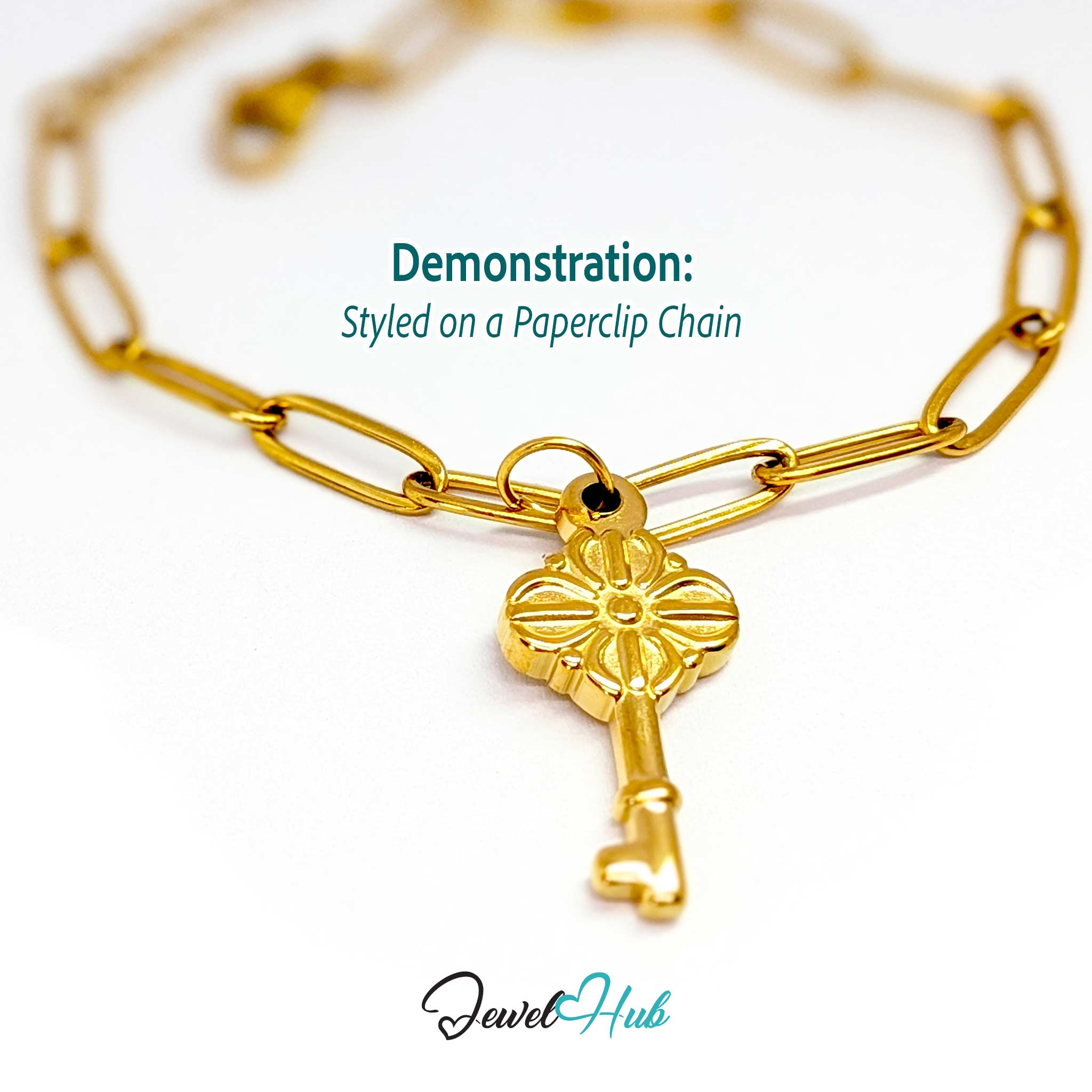 Vintage key charm in gold stainless steel with a quatrefoil bow - styled on a gold paperclip chain bracelet - JewelHub