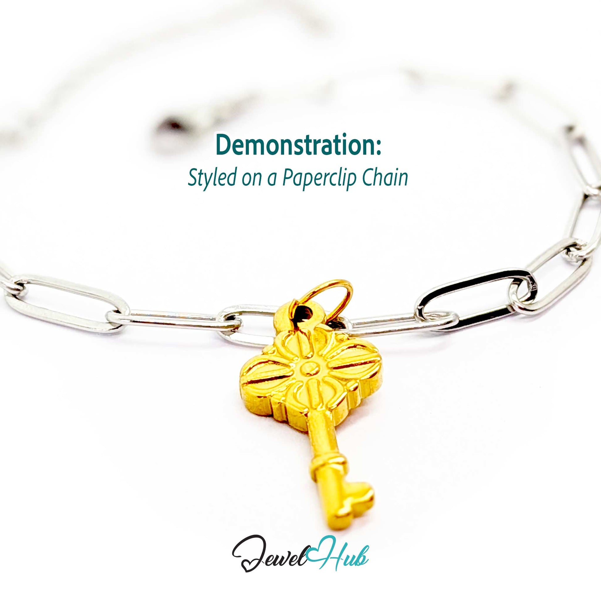 Vintage key charm in gold stainless steel with a quatrefoil bow - styled on a silver paperclip chain bracelet - JewelHub