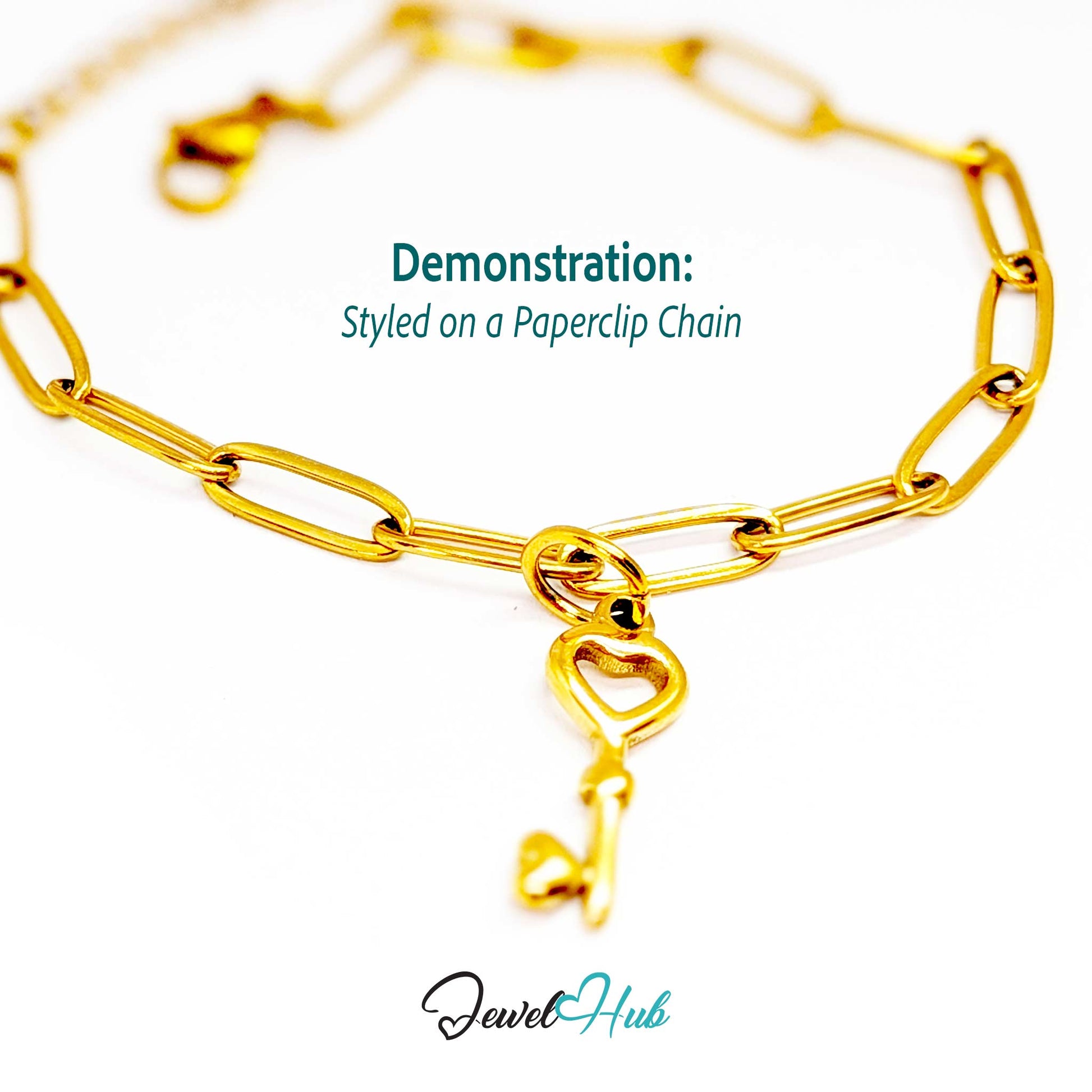 Heart key charm in gold stainless steel with an open heart bow - styled on a gold paperclip chain bracelet - JewelHub