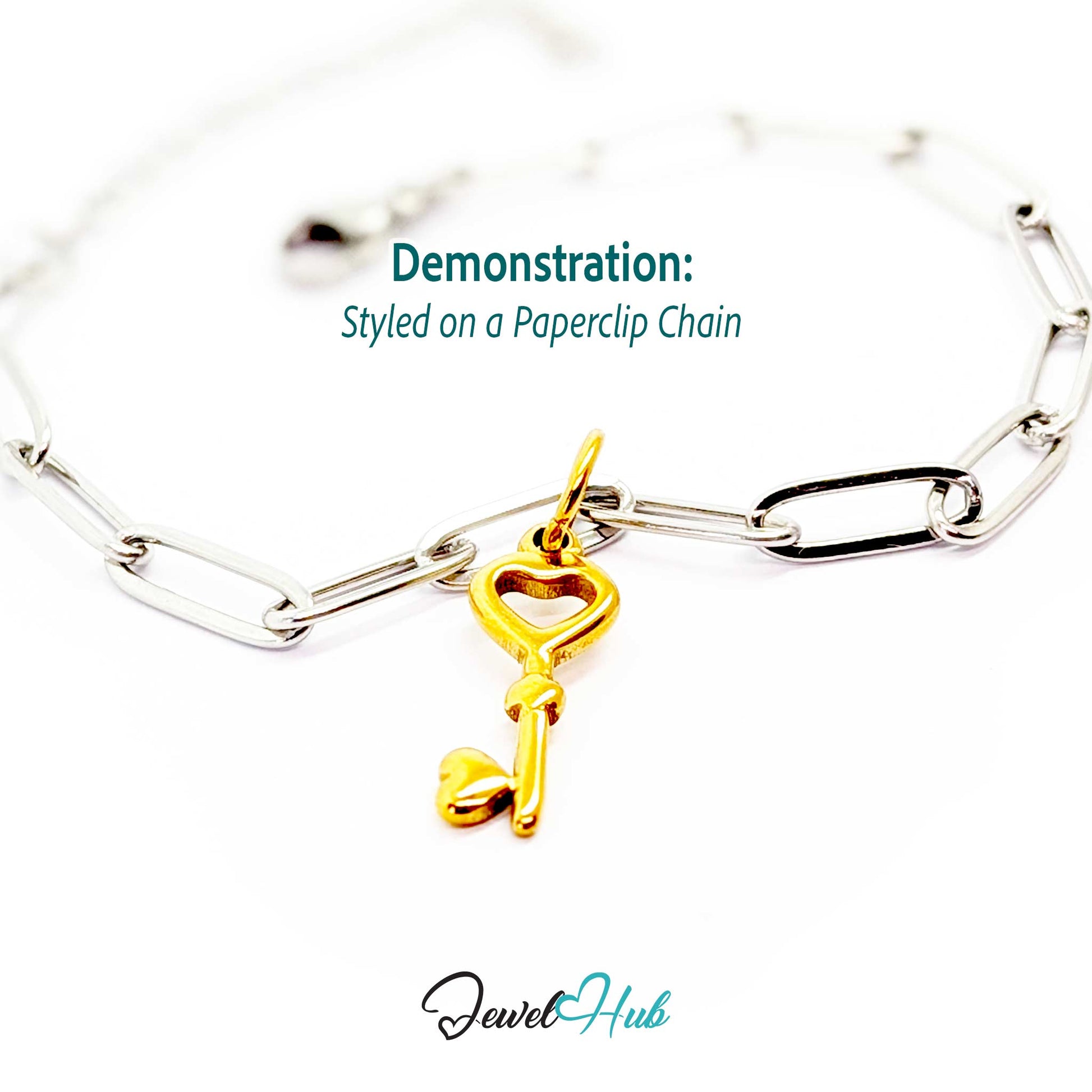 Heart key charm in gold stainless steel with an open heart bow - styled on a silver paperclip chain bracelet - JewelHub