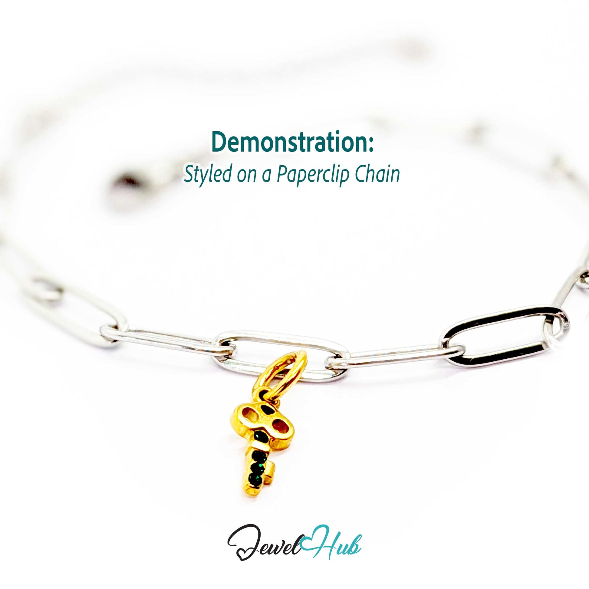 Mini key charm in gold stainless steel with four green stones - styled on a silver paperclip chain bracelet - JewelHub
