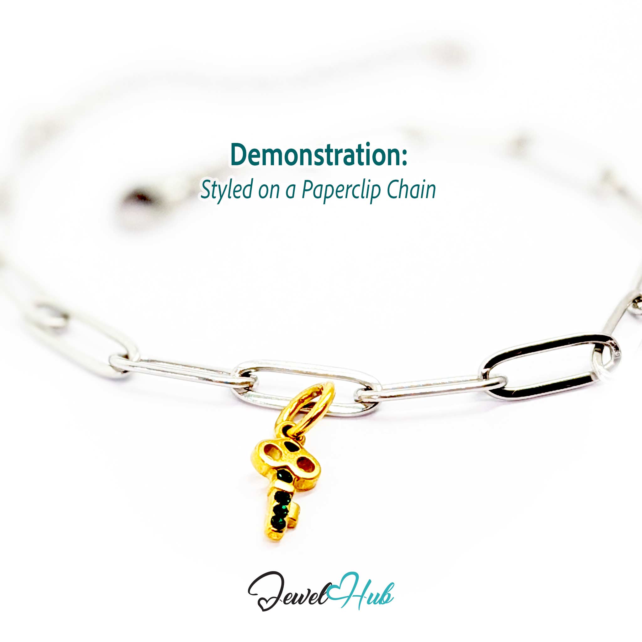 Mini key charm in gold stainless steel with four green stones - styled on a silver paperclip chain bracelet - JewelHub