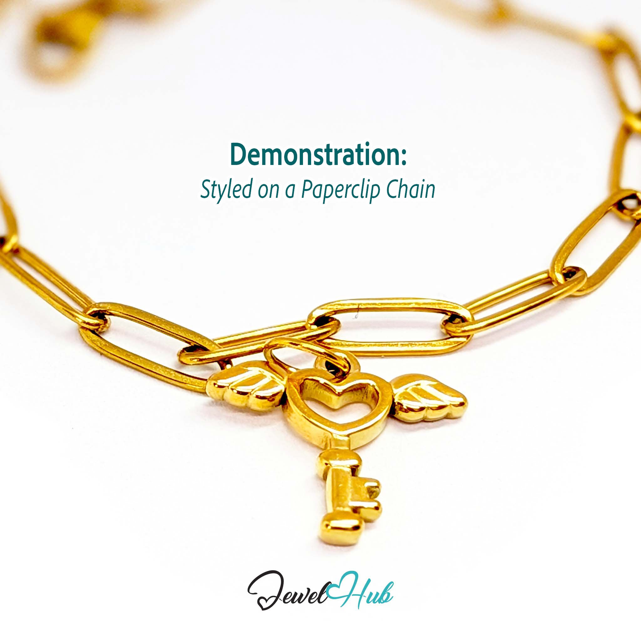 Winged heart key charm in gold stainless steel - styled on a gold paperclip chain bracelet - JewelHub