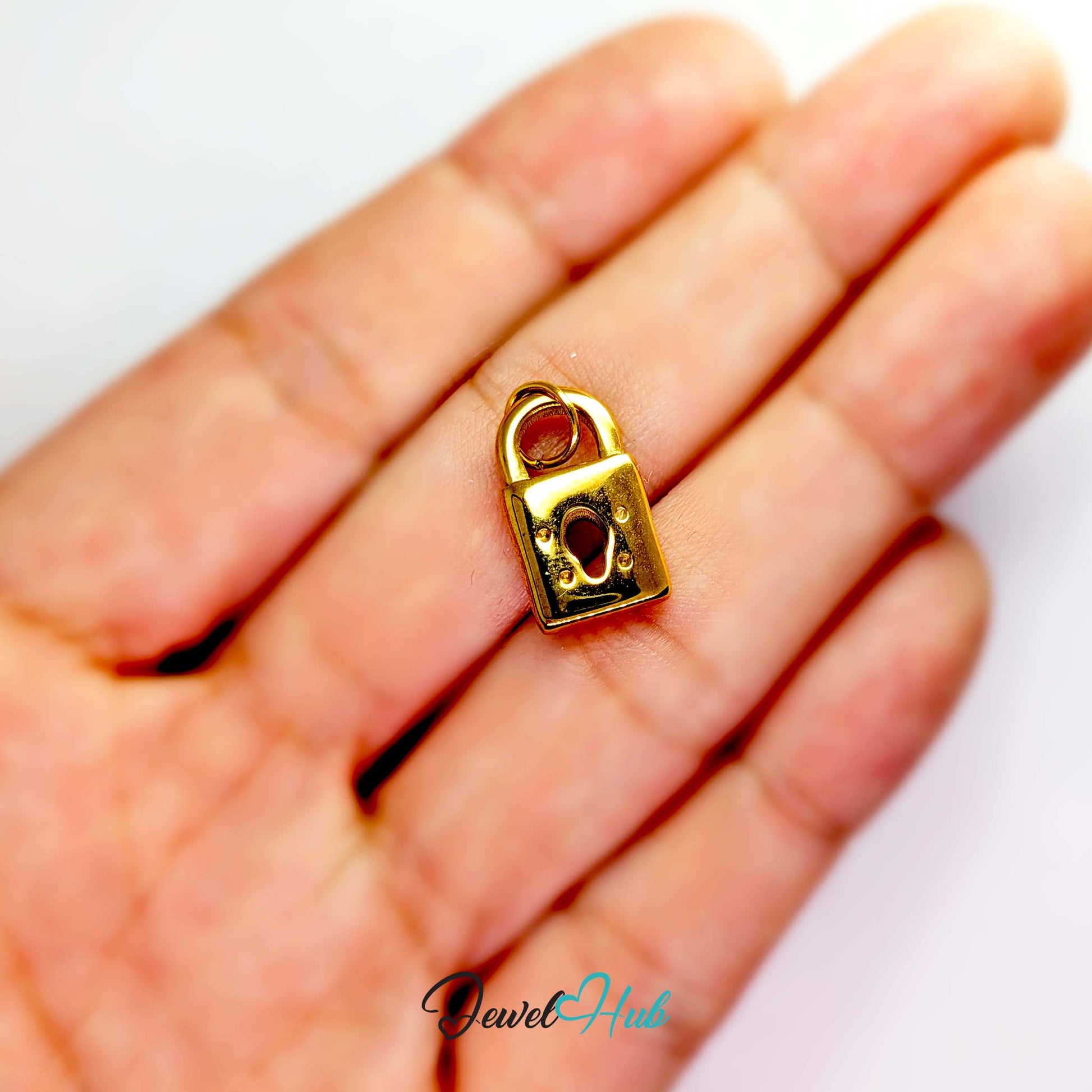 Classic padlock charm in gold stainless steel - held in the hand for scale - JewelHub