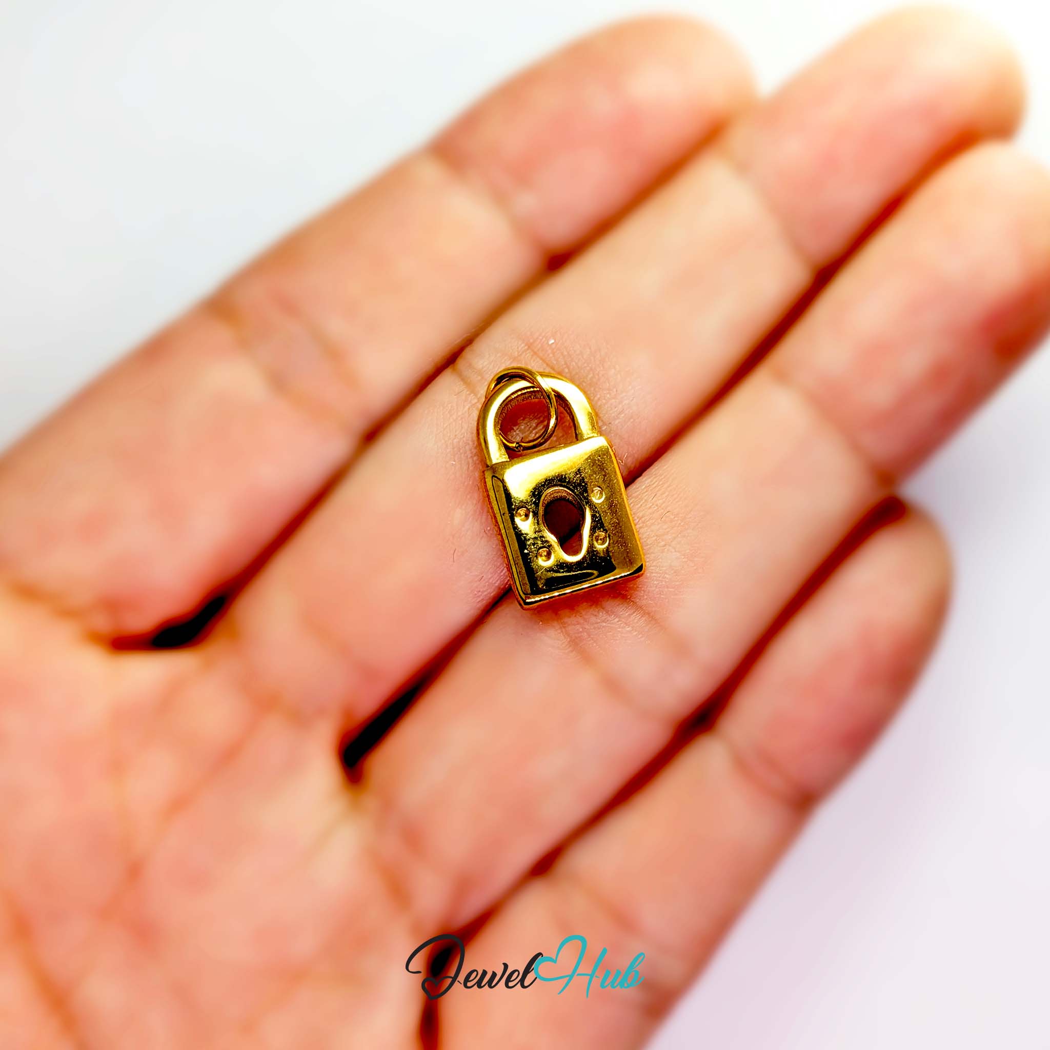 Classic padlock charm in gold stainless steel - held in the hand for scale - JewelHub