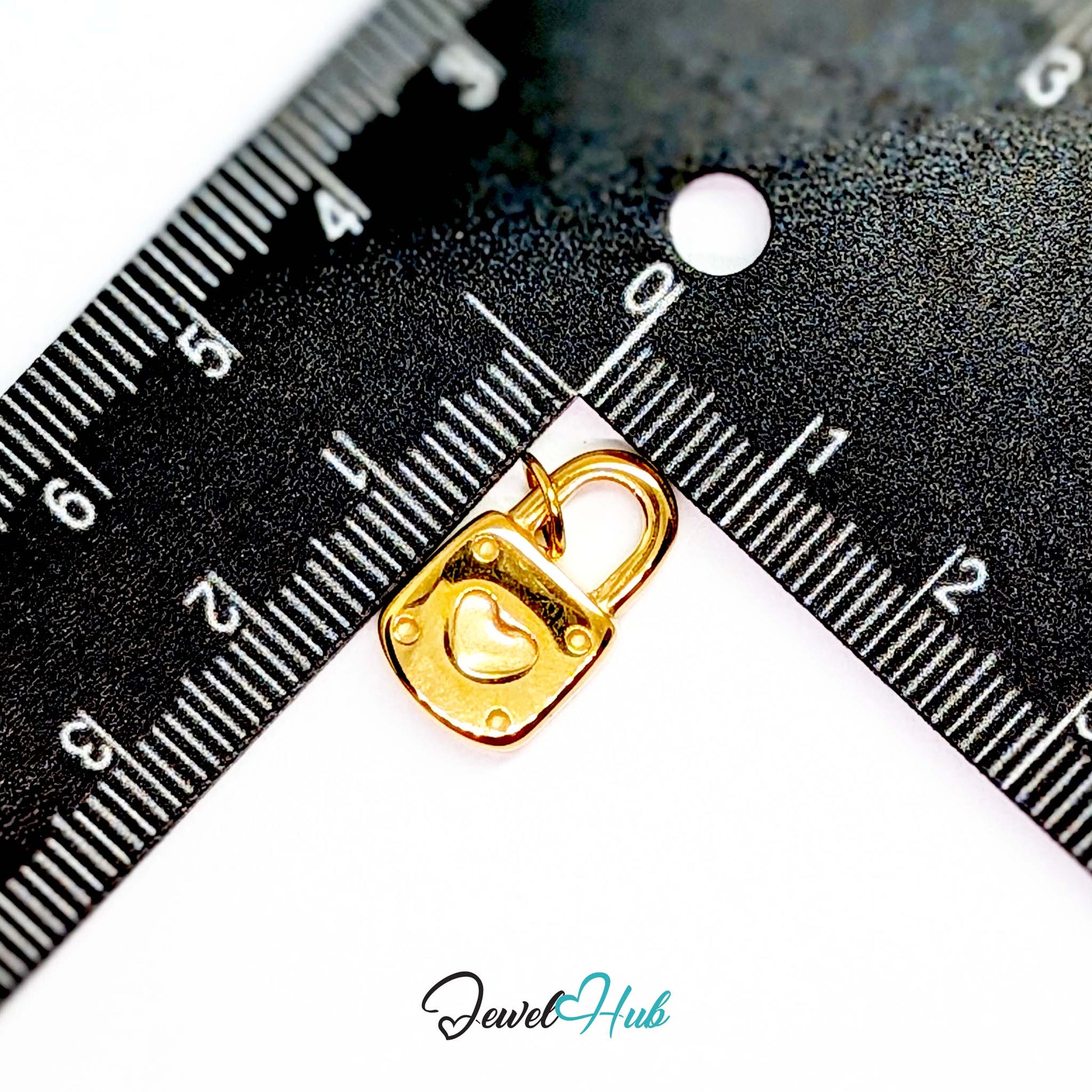 Heart padlock charm in gold stainless steel - beside a ruler for scale - JewelHub