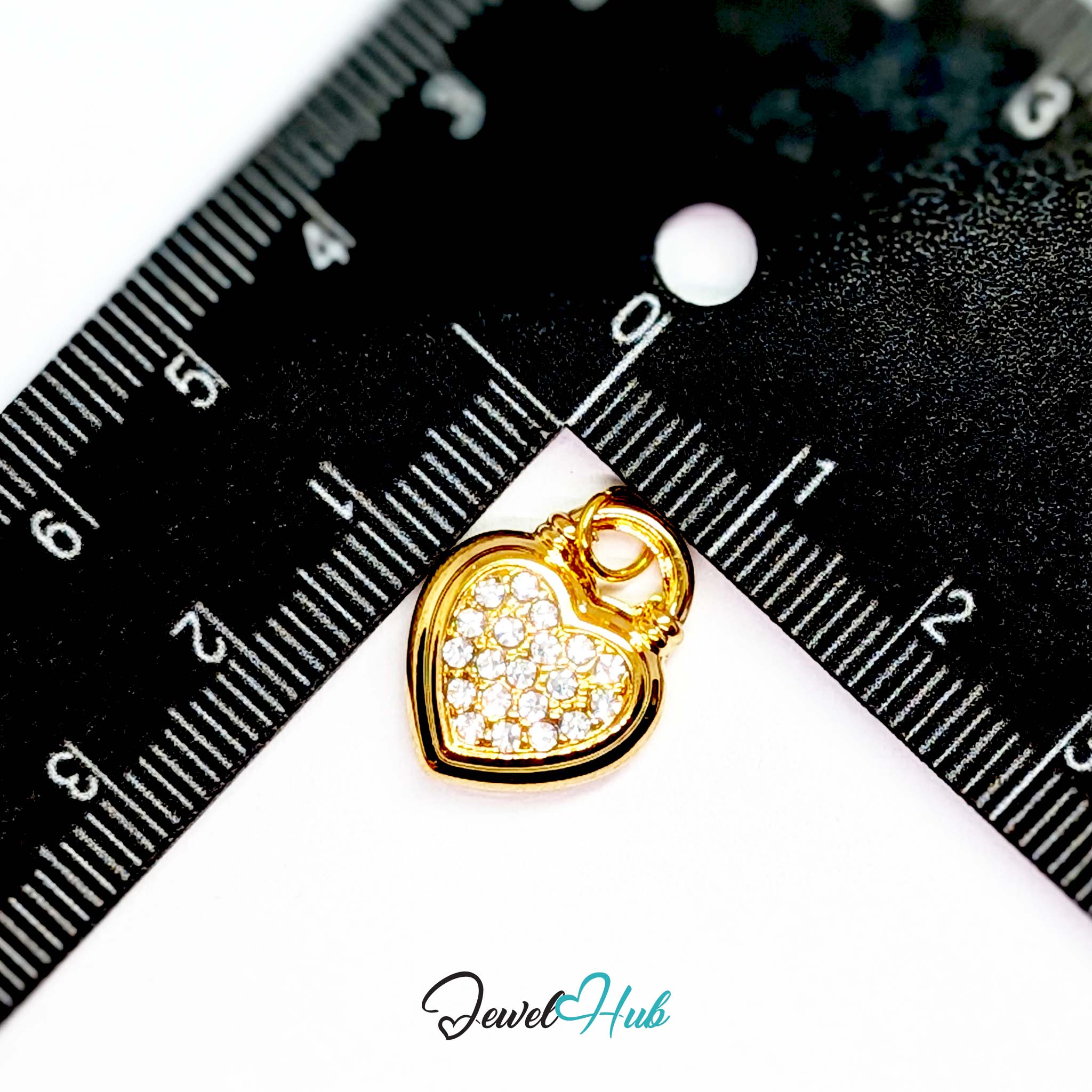 Pave heart padlock charm in gold stainless steel - beside a ruler for scale - JewelHub