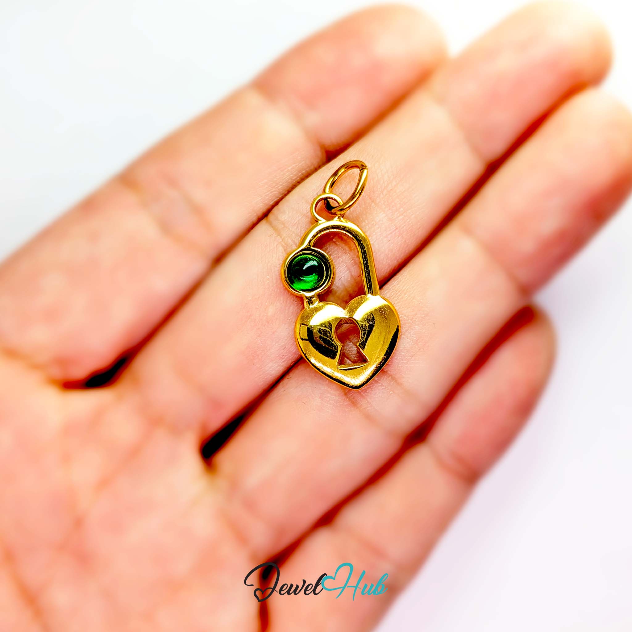 Green stone heart lock charm in gold stainless steel - held in the hand for scale - JewelHub