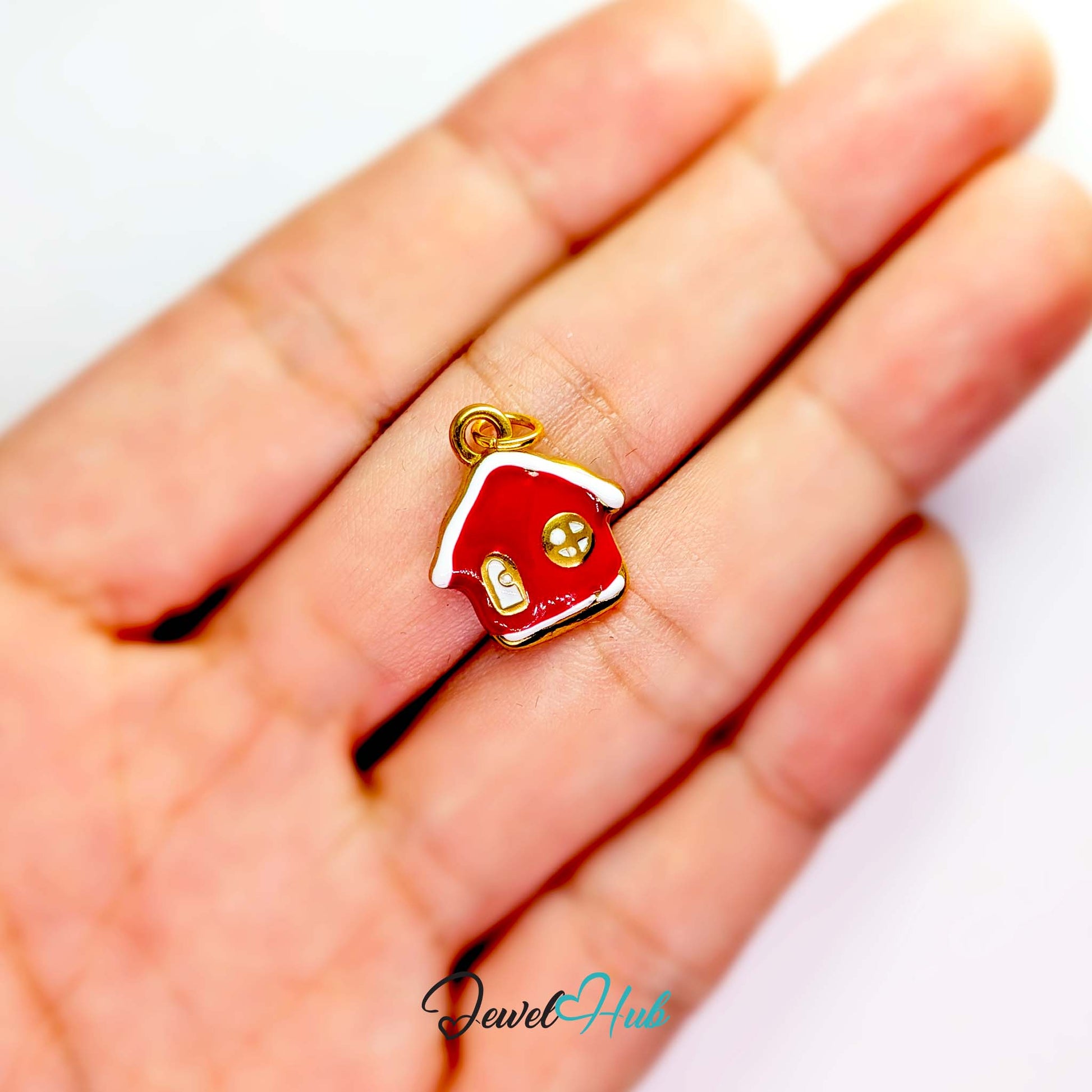 Red enamel house charm in gold stainless steel - held in the hand for scale - JewelHub