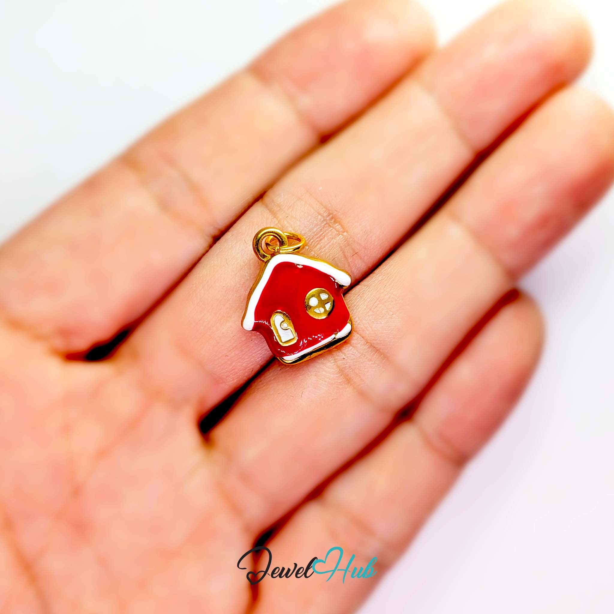 Red enamel house charm in gold stainless steel - held in the hand for scale - JewelHub