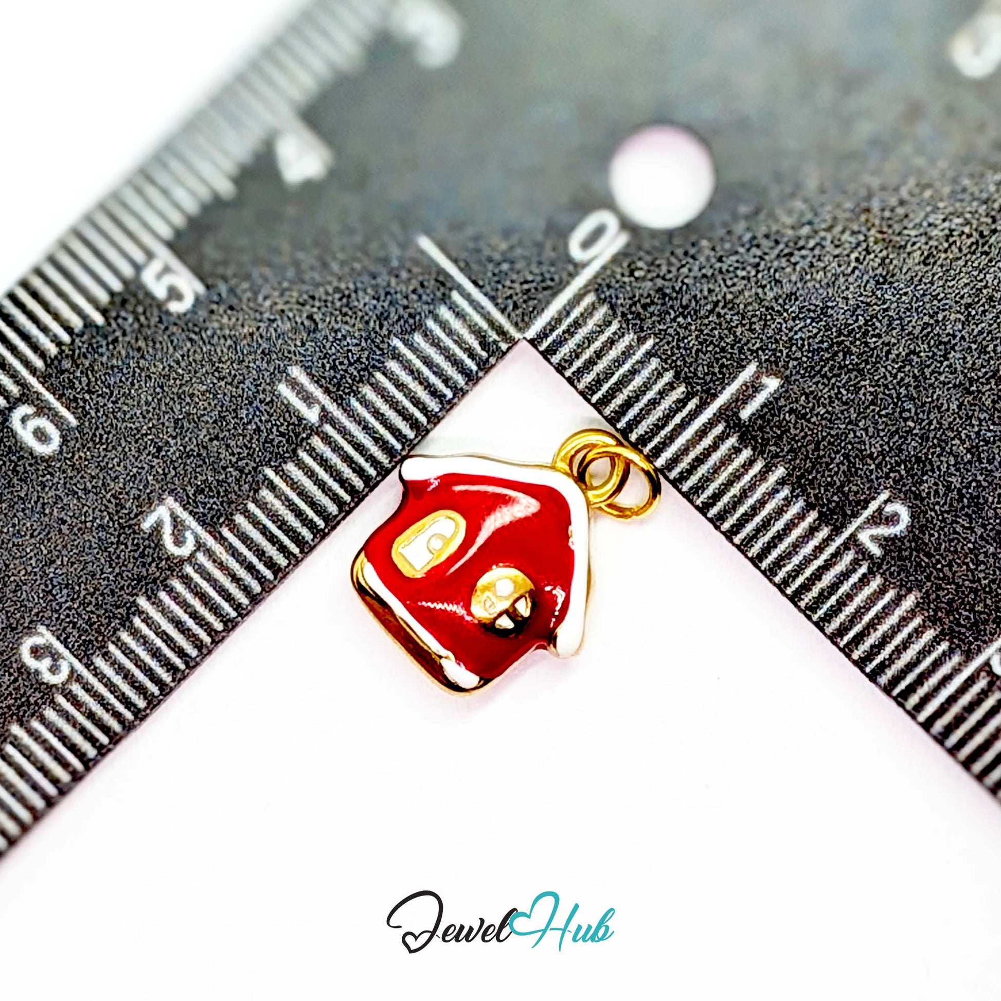 Red enamel house charm in gold stainless steel - beside a ruler for scale - JewelHub