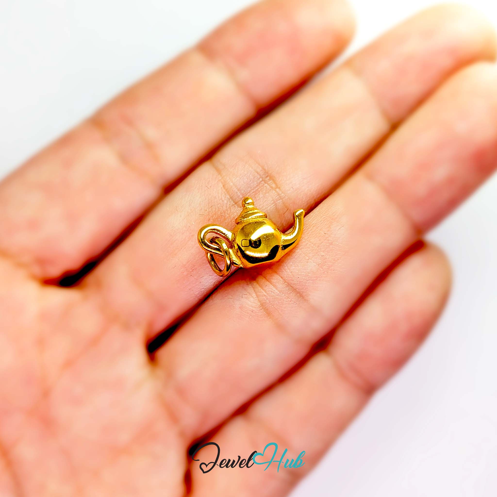 Three-dimensional teapot charm in gold stainless steel - held in the hand for scale - JewelHub