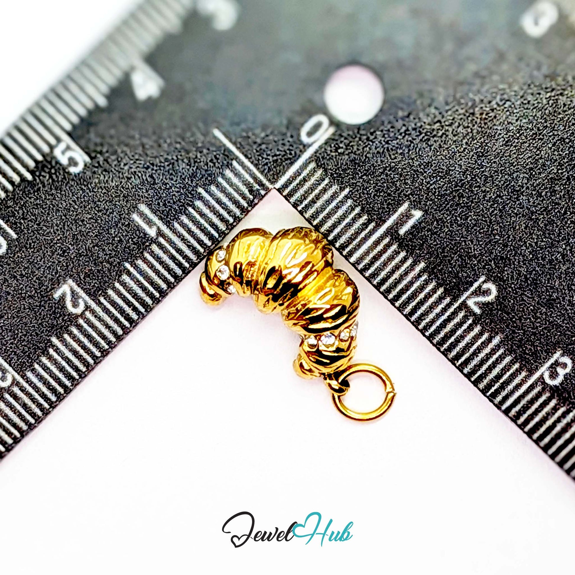Croissant charm in gold stainless steel with clear crystals - beside a ruler for scale - JewelHub