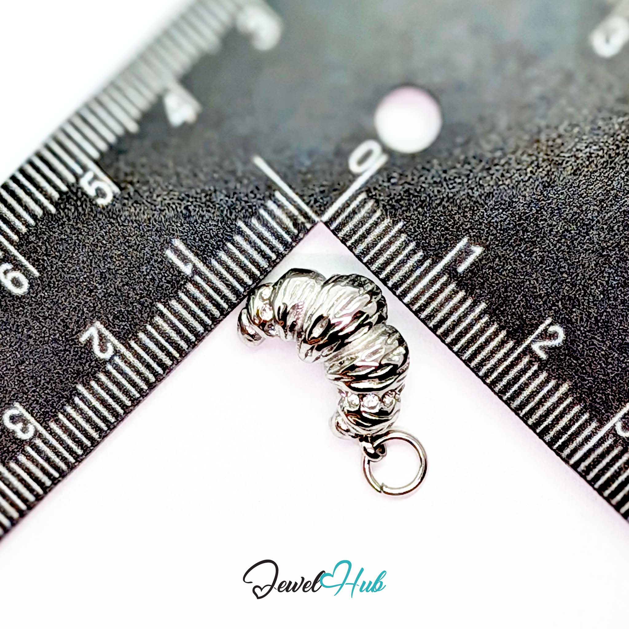 Croissant charm in silver stainless steel with clear crystals - beside a ruler for scale - JewelHub