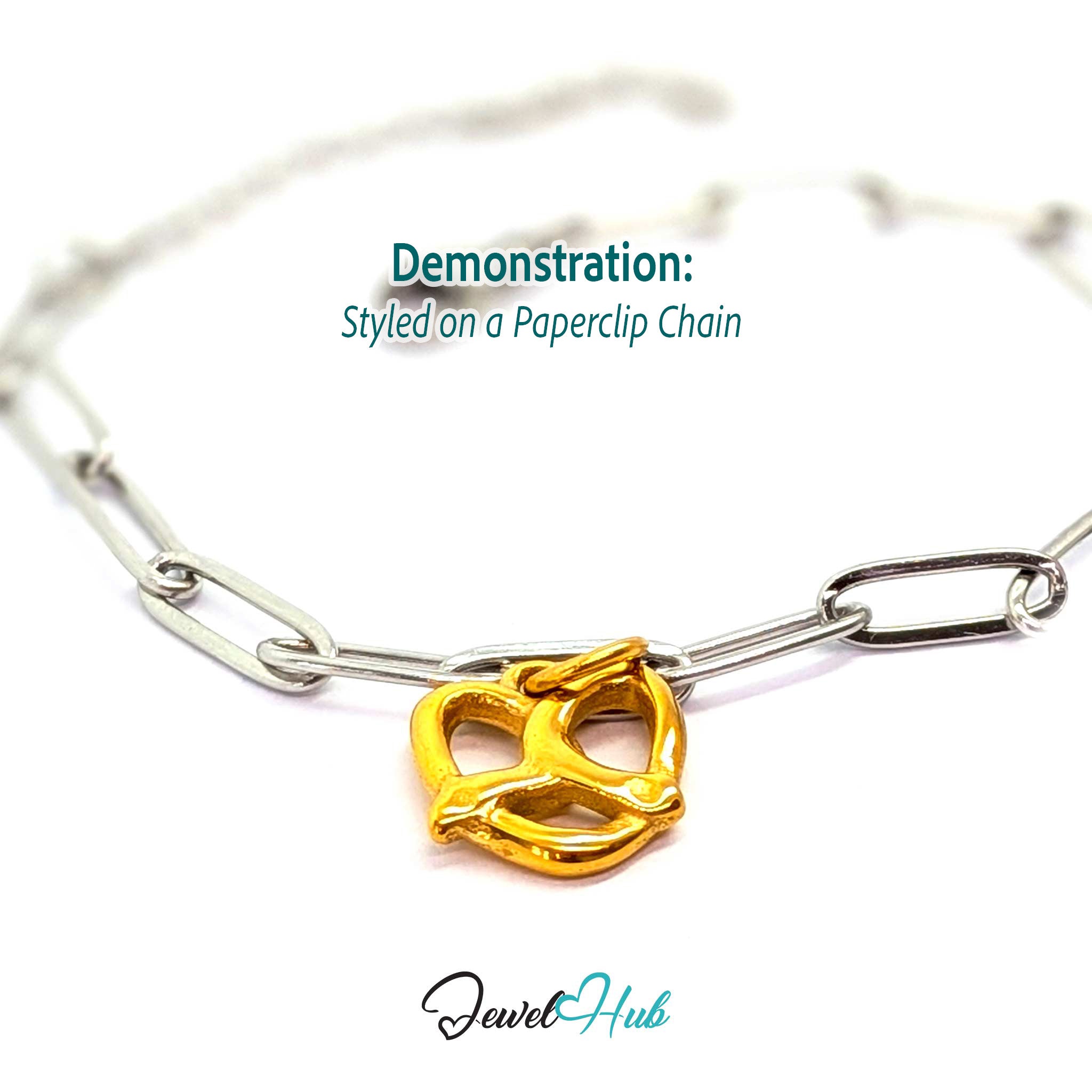 Openwork pretzel charm in gold stainless steel - styled on a silver paperclip chain bracelet - JewelHub