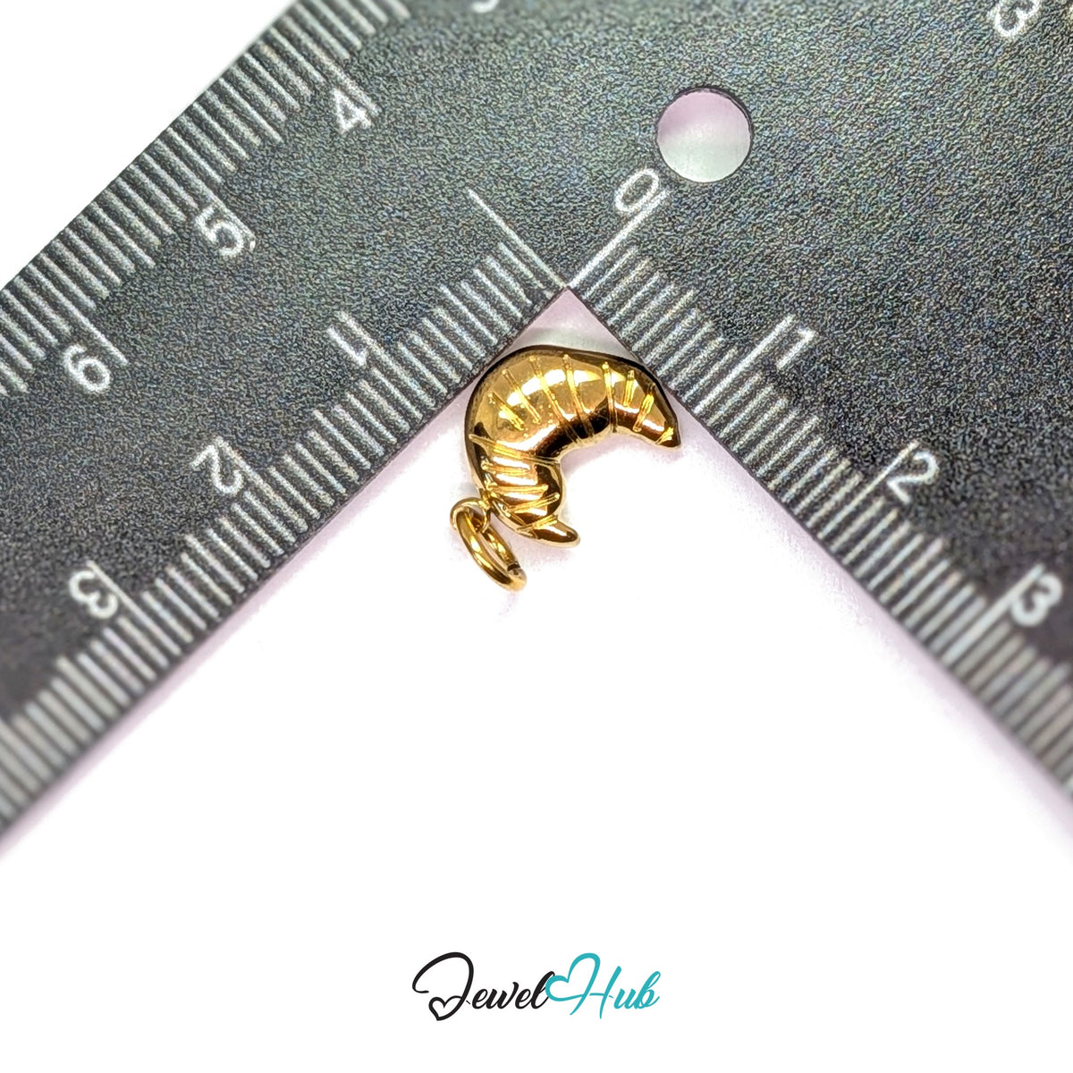 Slim ridged croissant charm measured against a ruler at 10.7mm wide by 19mm tall - JewelHub