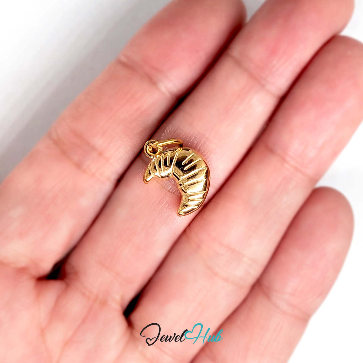 Curved croissant charm held in a hand to show its size - JewelHub