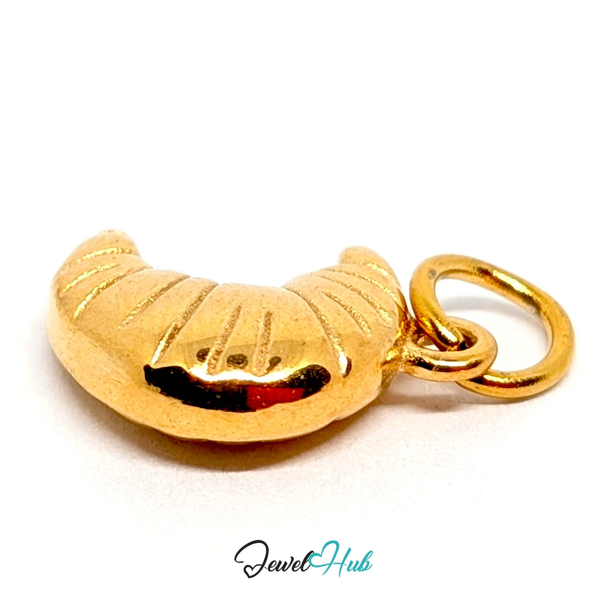 Close-up of the gold-tone curved croissant charm detail - JewelHub