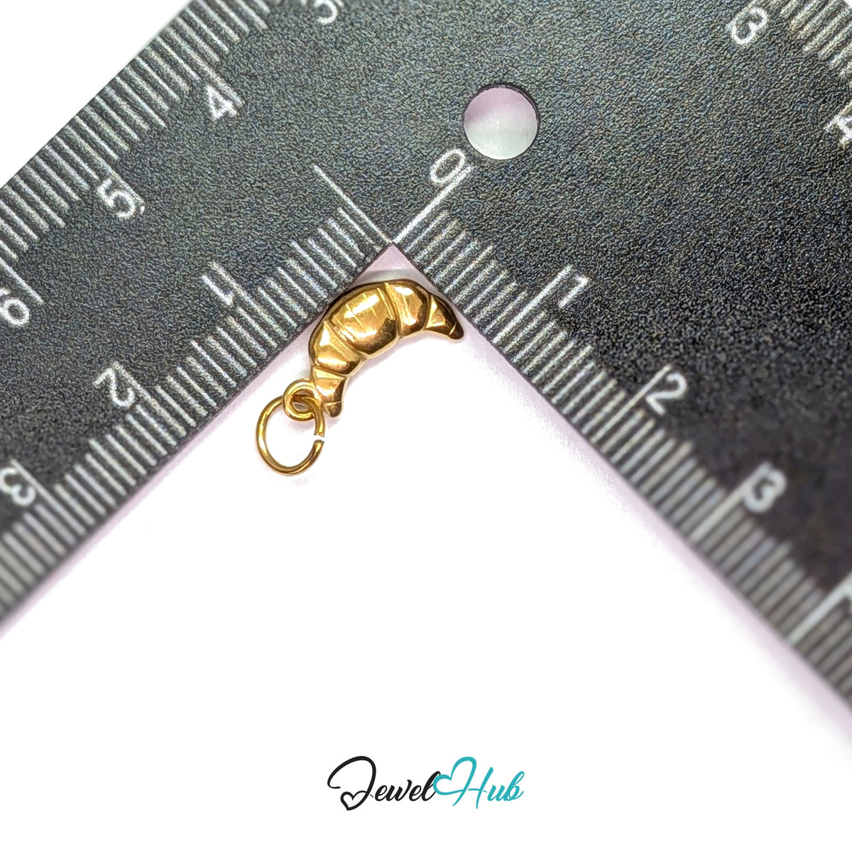 Mini croissant charm measured against a ruler at 7.2mm wide by 14mm tall - JewelHub
