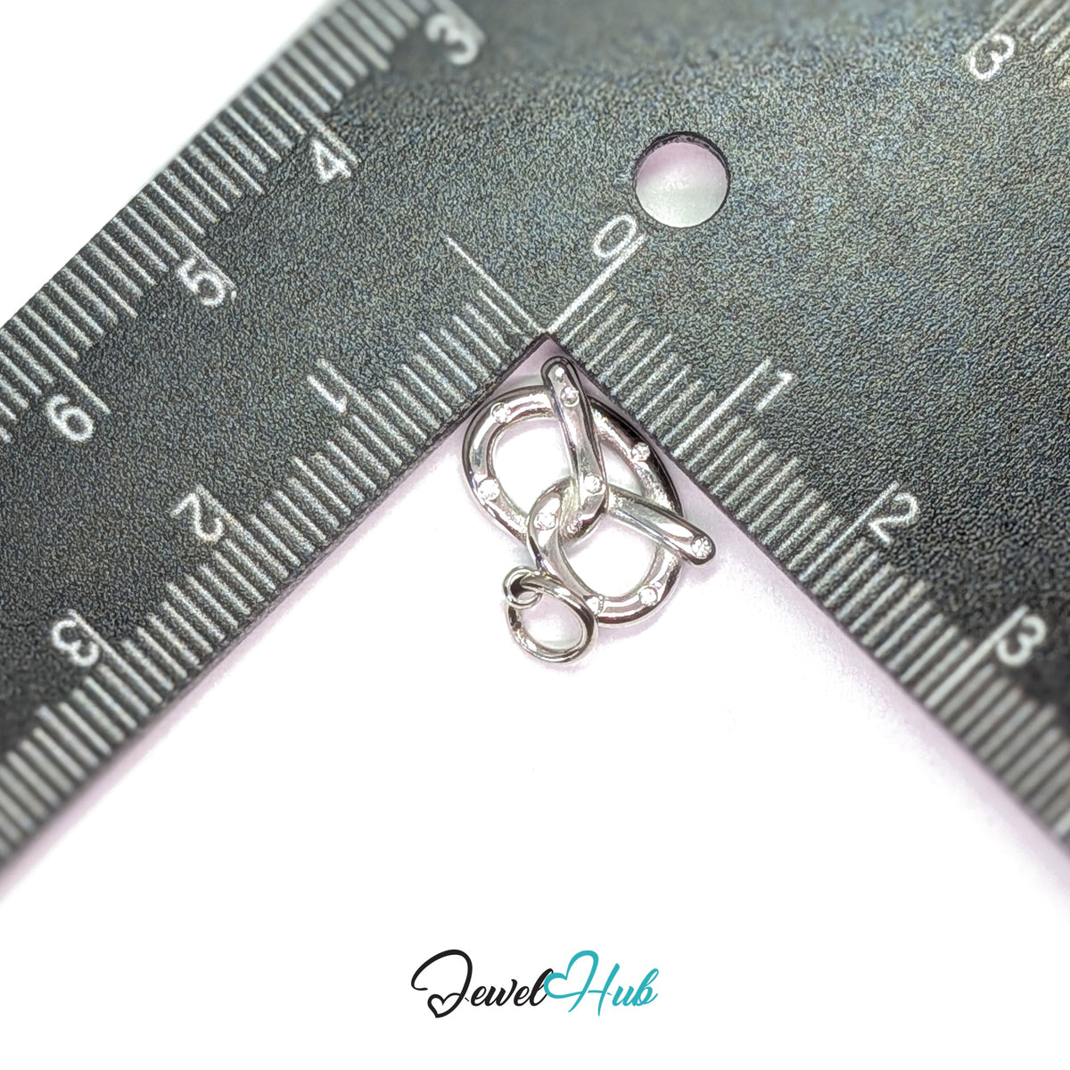 Pretzel charm measured against a ruler at 15.3mm wide by 12.1mm tall - JewelHub