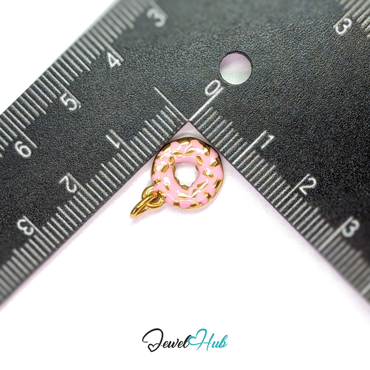 Pink sprinkle donut charm measured against a ruler at 12mm wide by 15mm tall - JewelHub