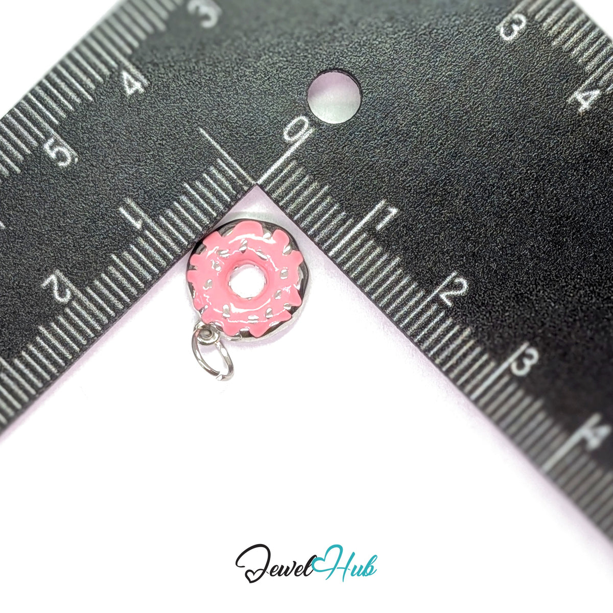 Pink sprinkle donut charm measured against a ruler at 12mm wide by 15mm tall - JewelHub