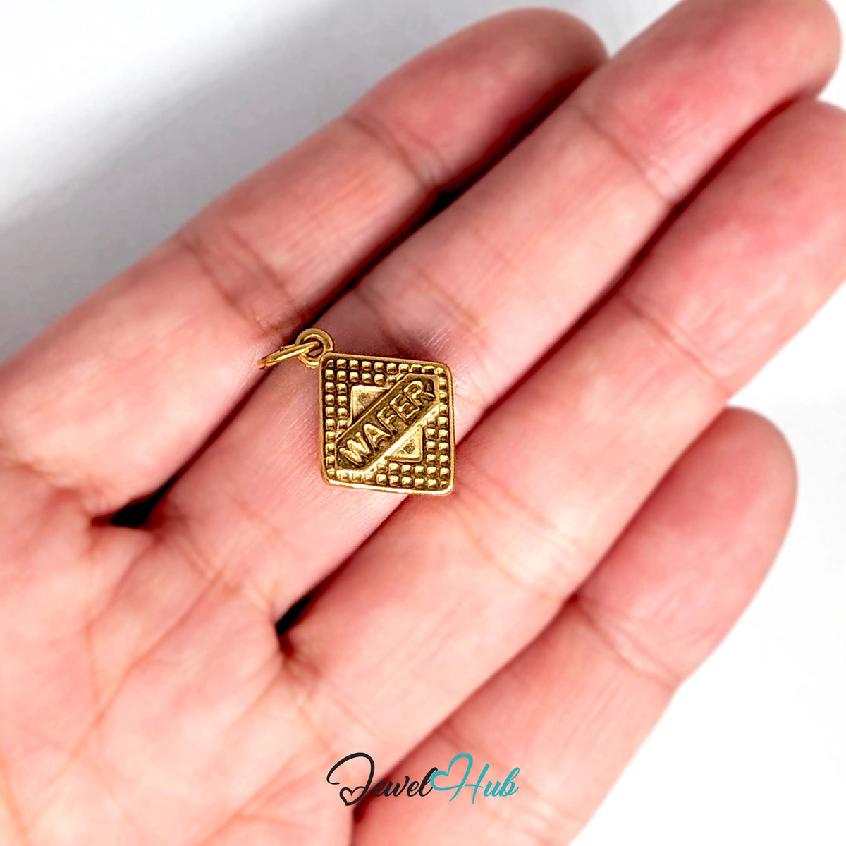 Wafer biscuit charm held in a hand to show its size - JewelHub