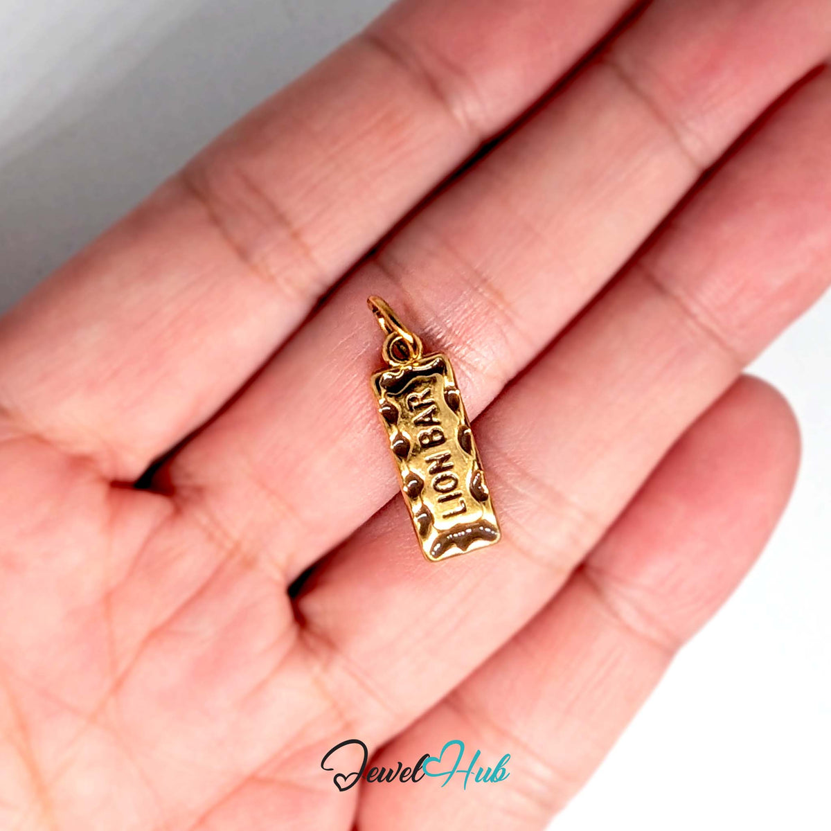 Chocolate bar charm held in a hand to show its size - JewelHub