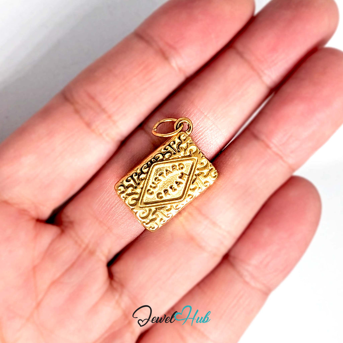 Custard cream biscuit charm held in a hand to show its size - JewelHub