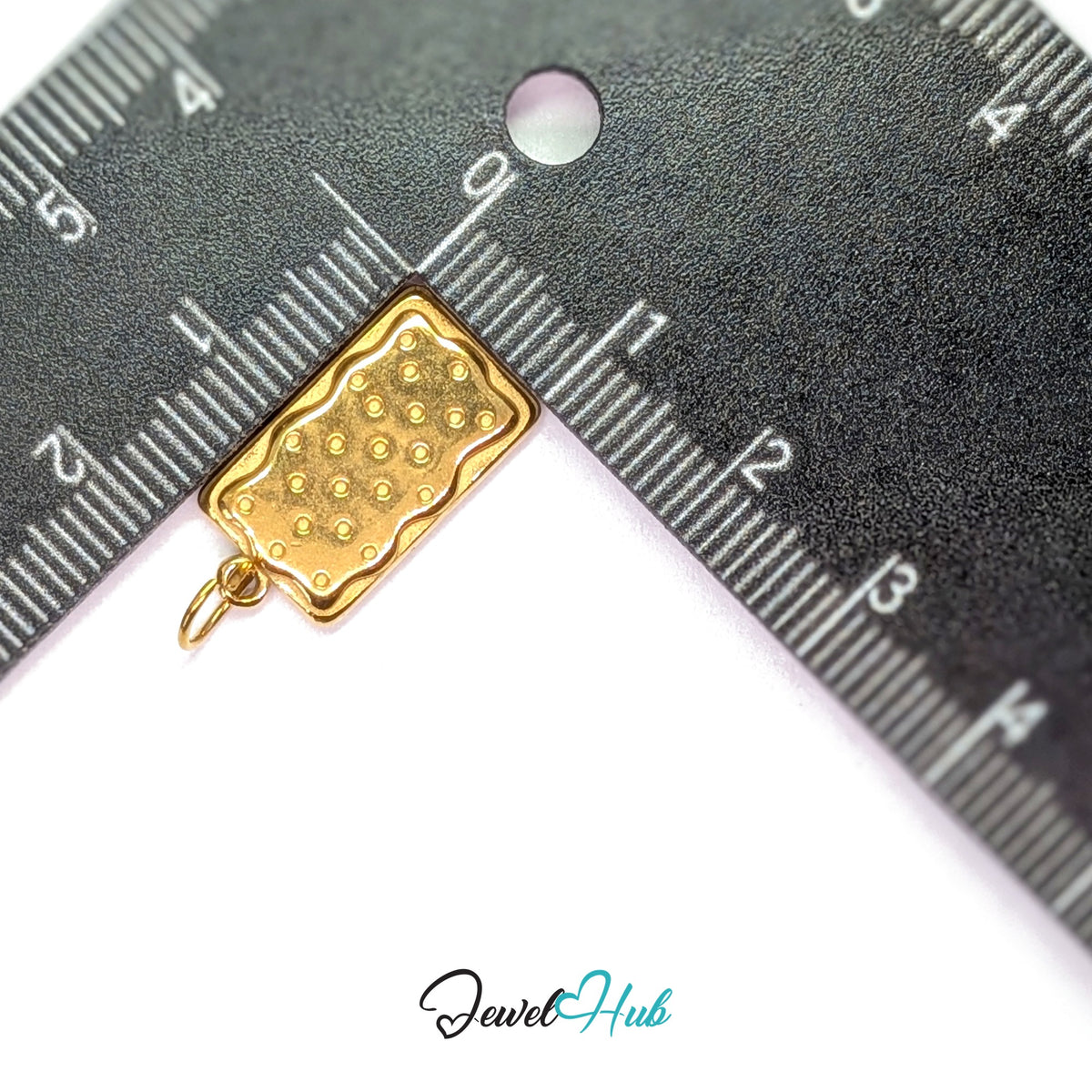 Dotted biscuit charm measured against a ruler at 10.8mm wide by 20.4mm tall - JewelHub