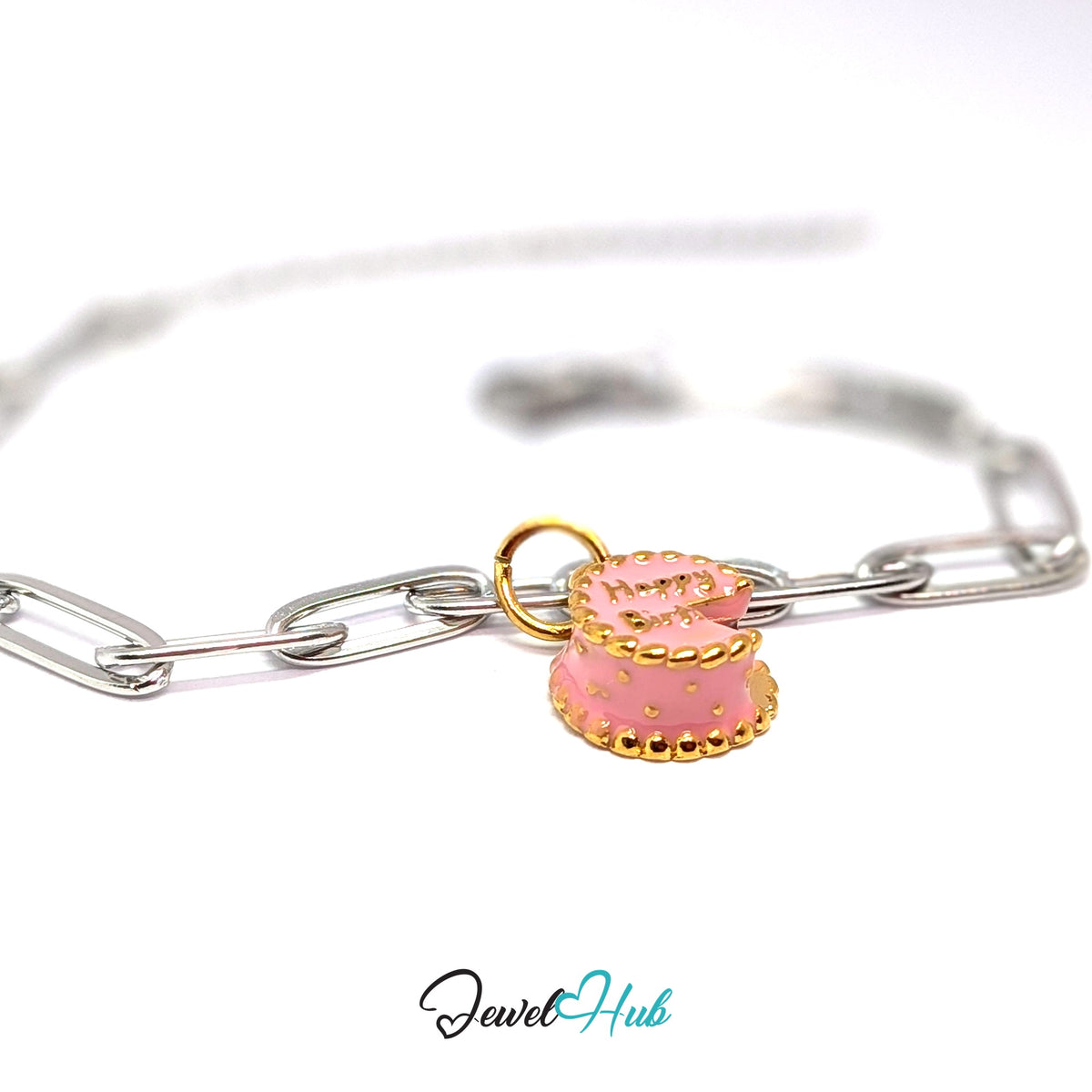 Gold-tone pink birthday cake charm styled on a silver paperclip chain bracelet for a two-tone look - JewelHub