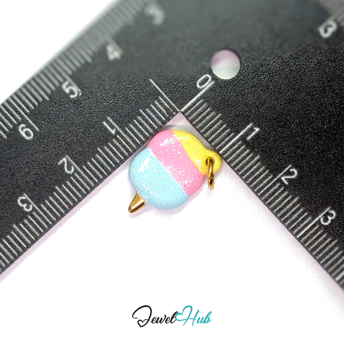 Pastel glitter cotton candy charm measured against a ruler at 12.5mm wide by 18mm tall - JewelHub