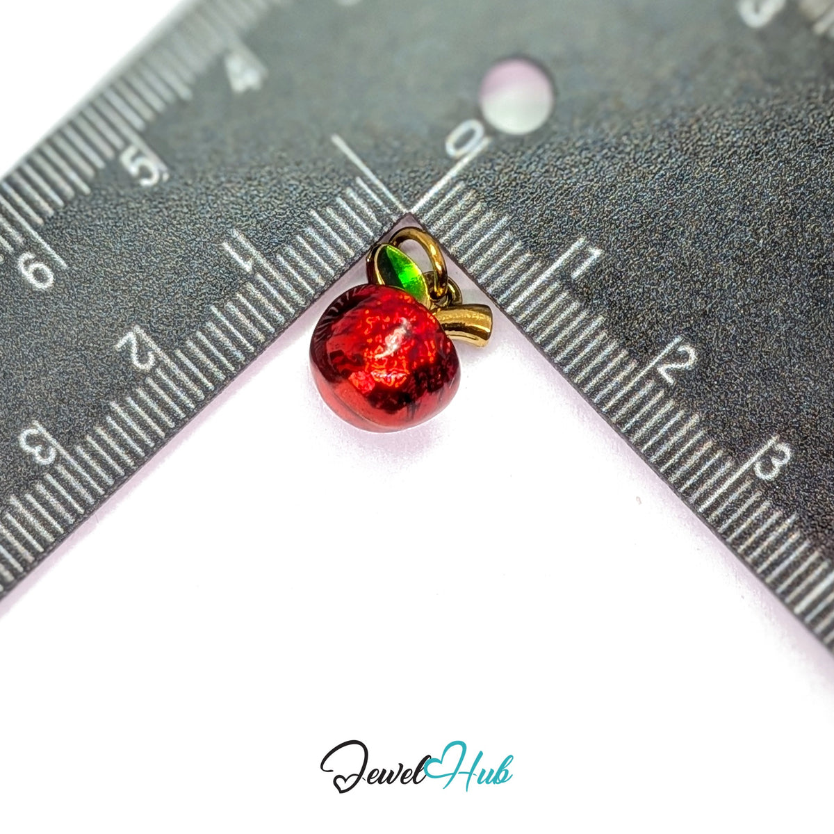 Red apple charm measured against a ruler at 11.1mm wide by 14mm tall - JewelHub