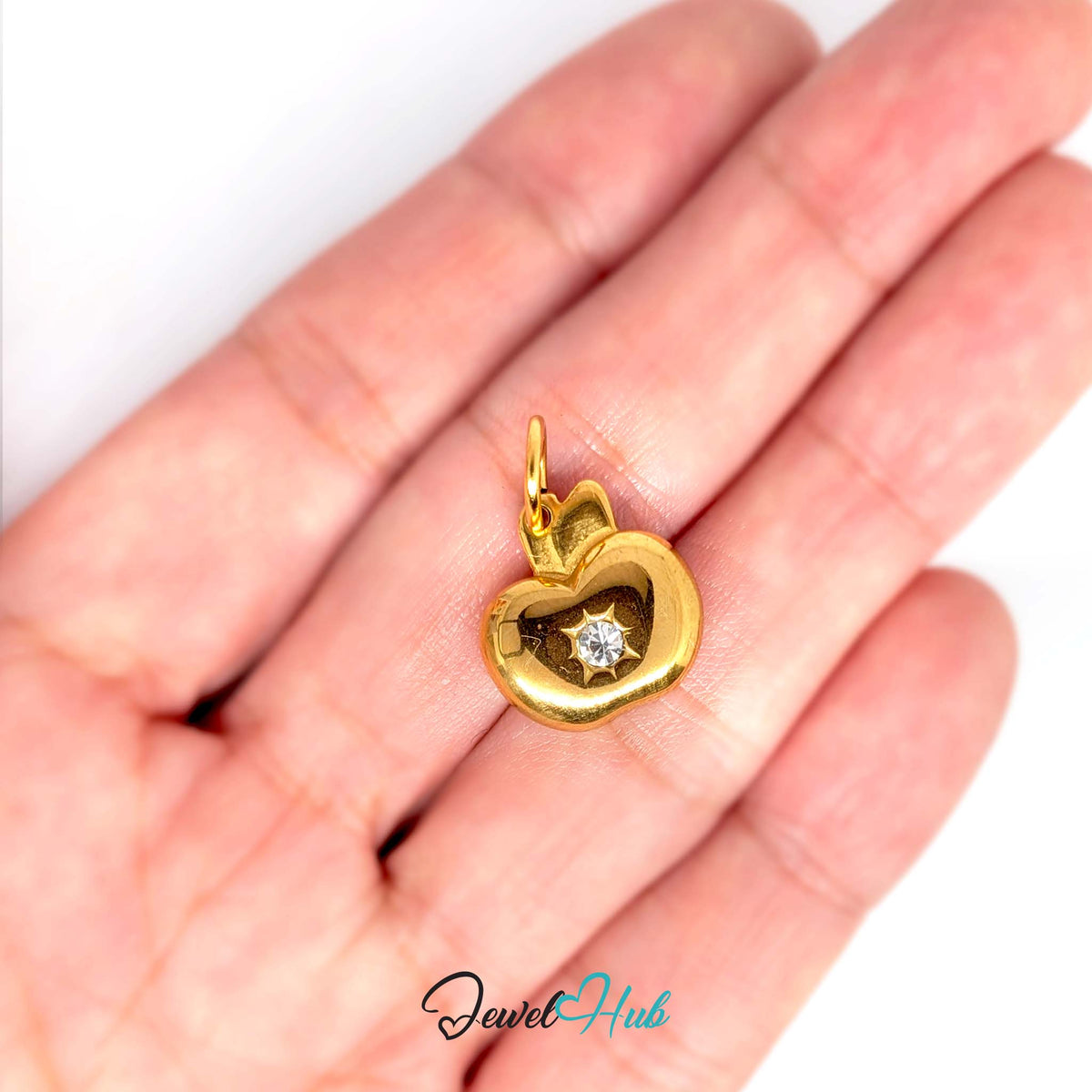 Crystal apple charm held in a hand to show its size - JewelHub