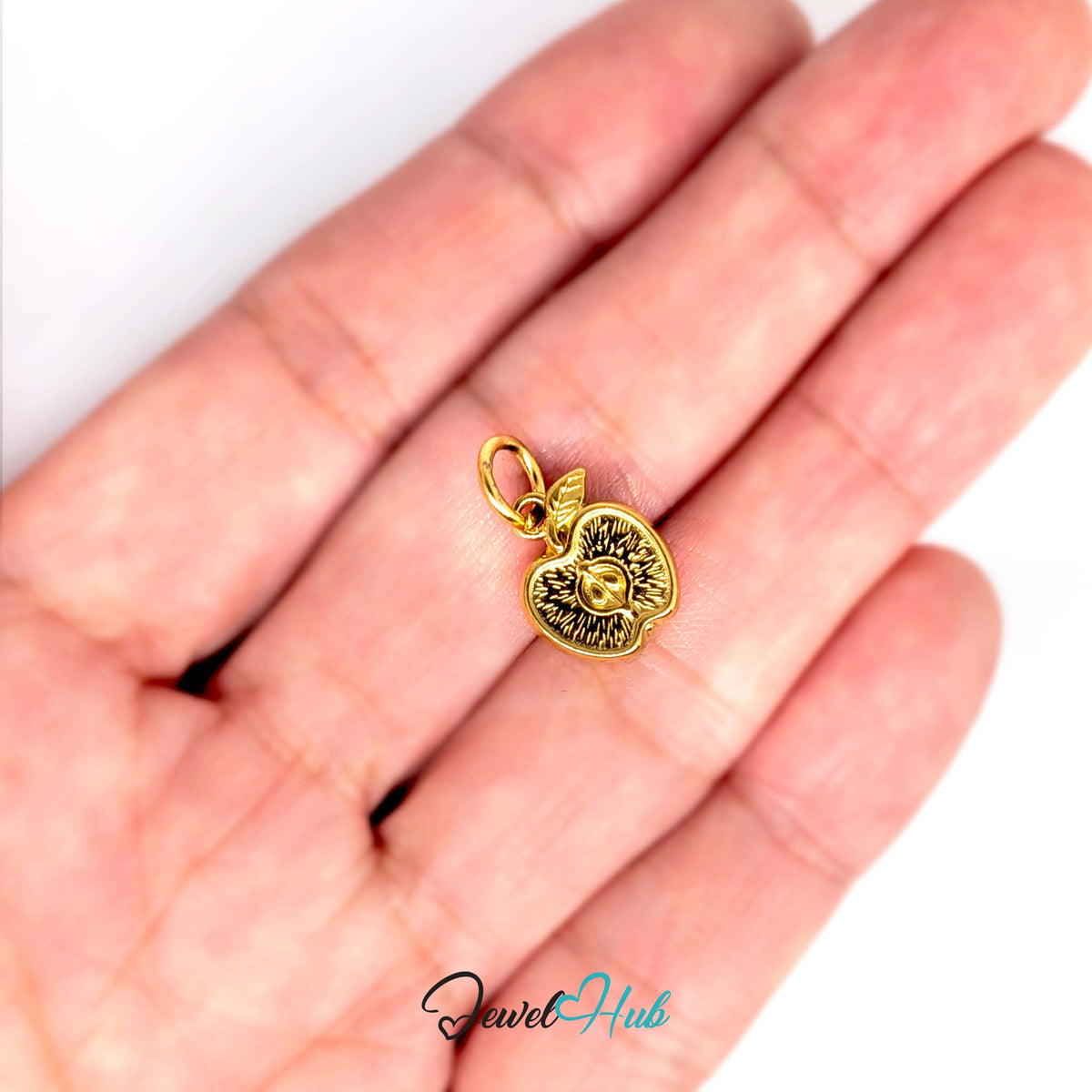 Apple half charm held in a hand to show its size - JewelHub