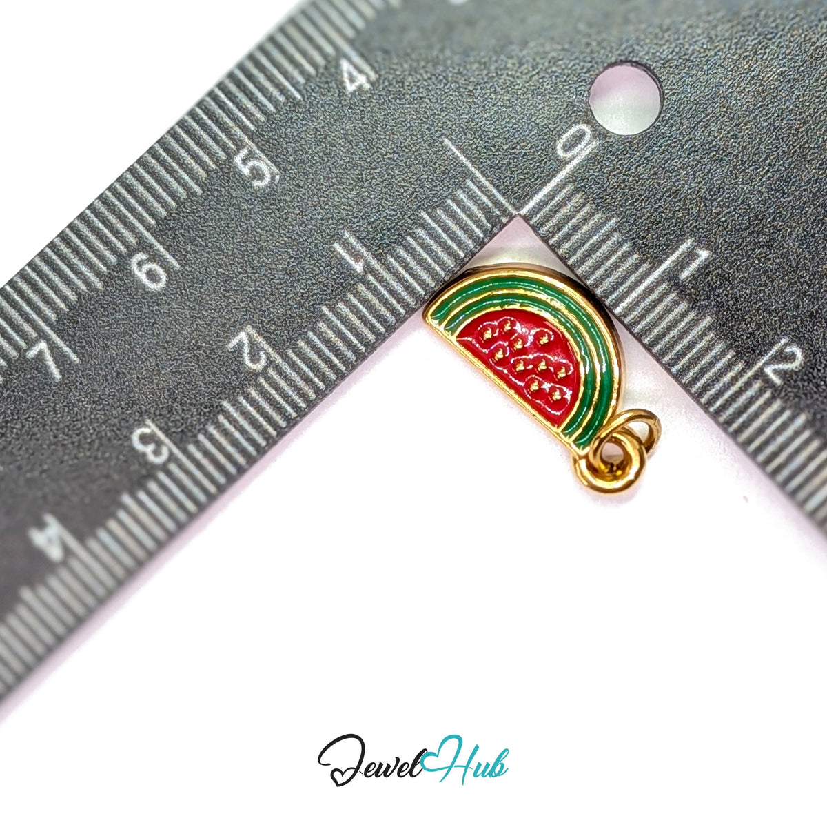 Watermelon slice charm measured against a ruler at 9.8mm wide by 20.5mm tall - JewelHub