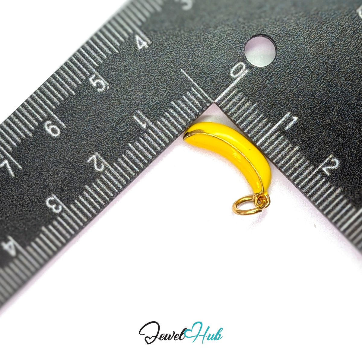 Yellow enamel banana charm measured against a ruler at 7.3mm wide by 19mm tall - JewelHub