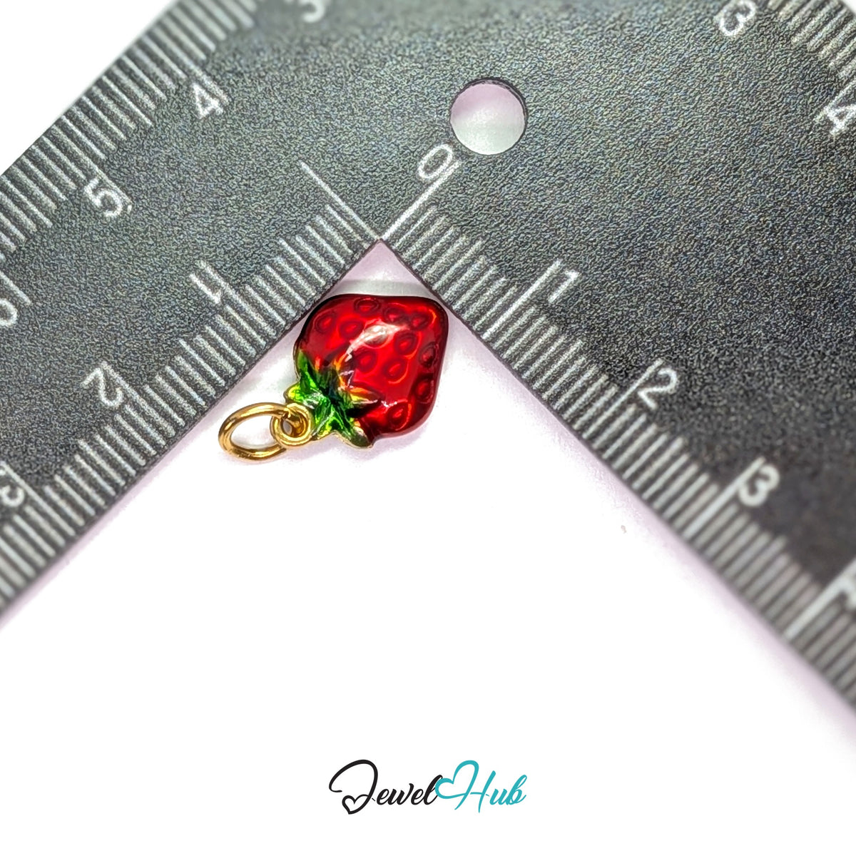 Red enamel strawberry charm measured against a ruler at 11.2mm wide by 15.2mm tall - JewelHub