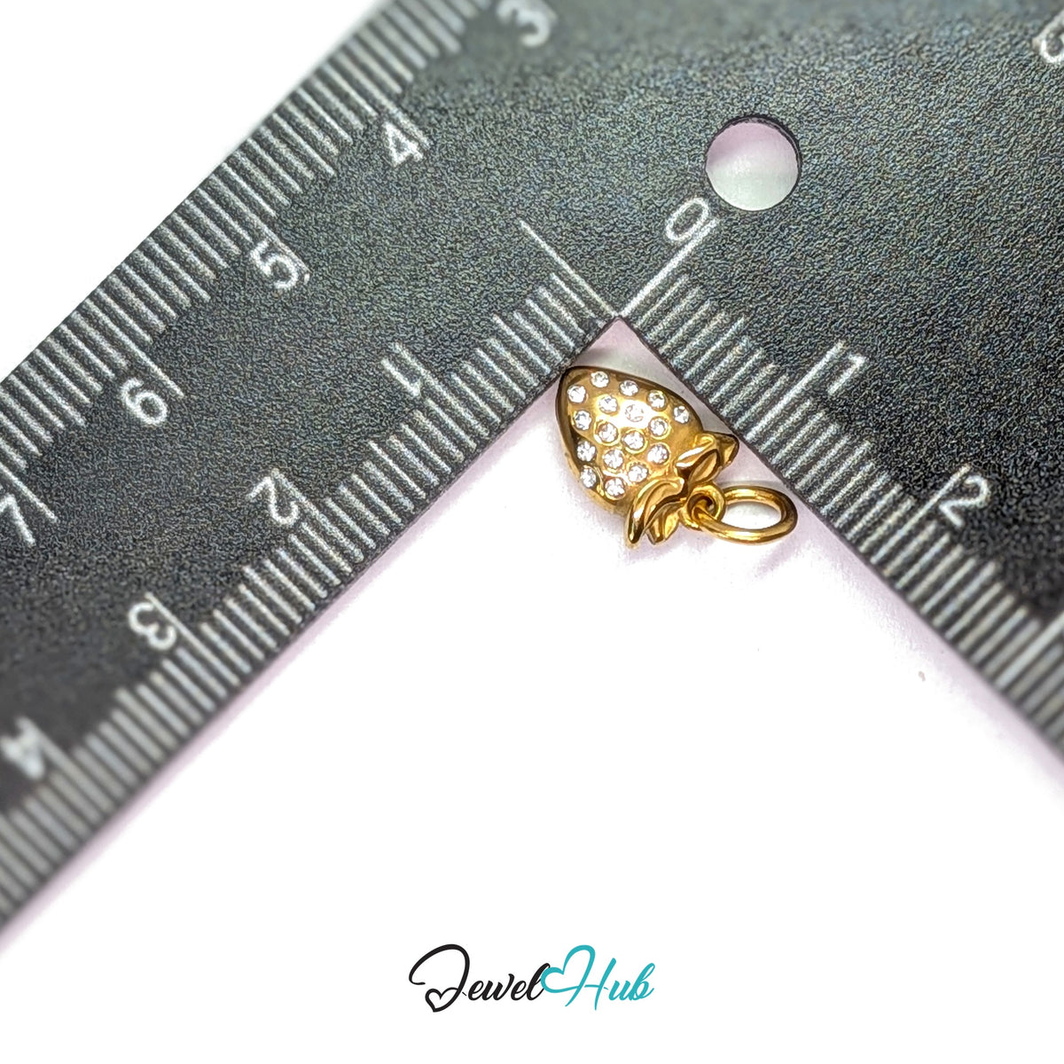 Crystal strawberry charm measured against a ruler at 9.2mm wide by 12.5mm tall - JewelHub