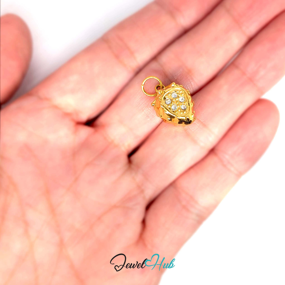 3D crystal strawberry charm held in a hand to show its size - JewelHub