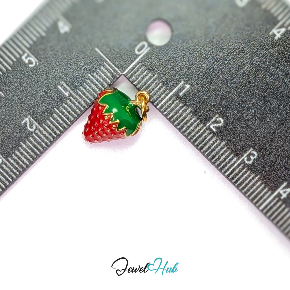 3D red enamel strawberry charm measured against a ruler at 11.5mm wide by 17.5mm tall - JewelHub