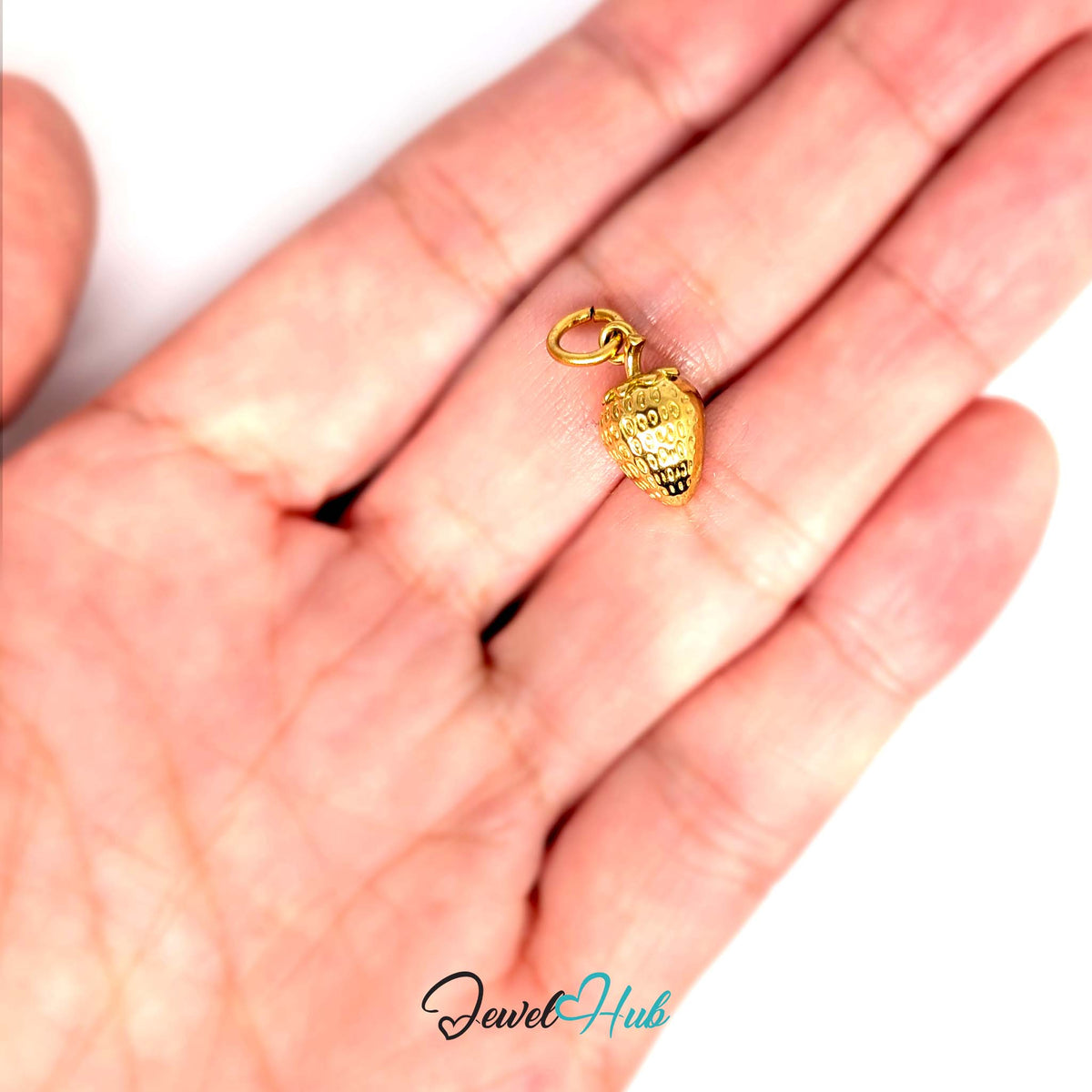 Mini 3D strawberry charm held in a hand to show its size - JewelHub