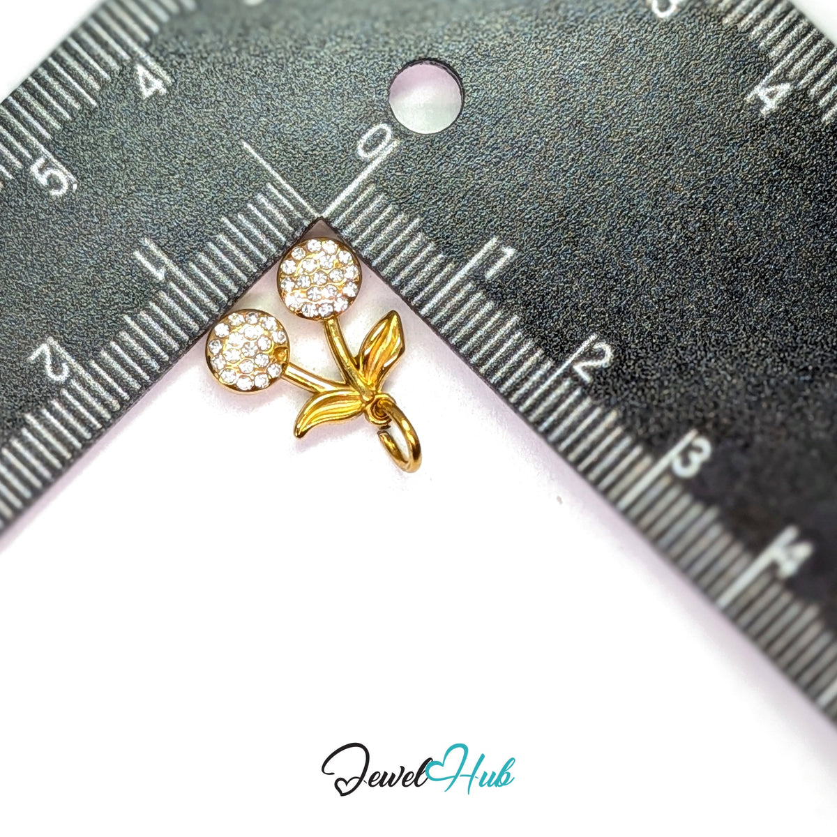 Crystal cherry charm measured against a ruler at 13.8mm wide by 14.2mm tall - JewelHub