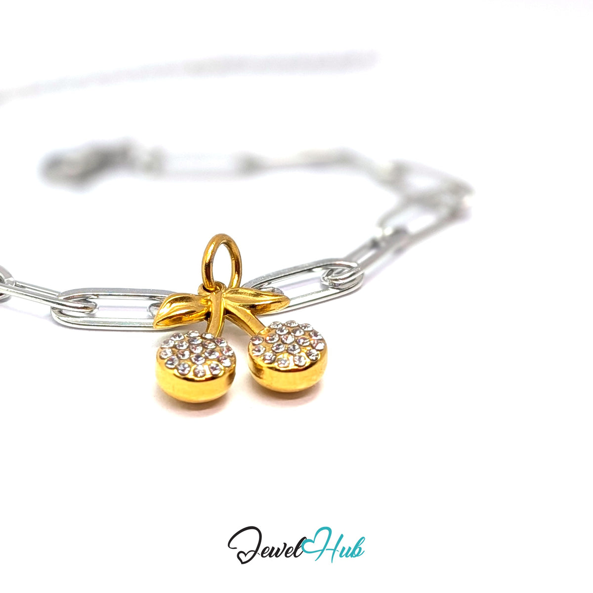Gold-tone crystal cherry charm styled on a silver paperclip chain bracelet for a two-tone look - JewelHub