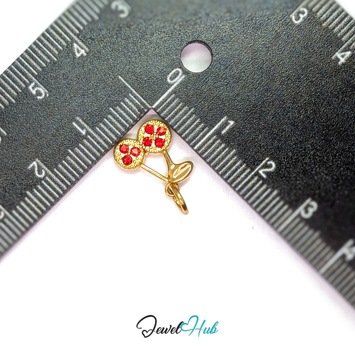 Red stone cluster cherry charm measured against a ruler at 11.1mm wide by 13.4mm tall - JewelHub