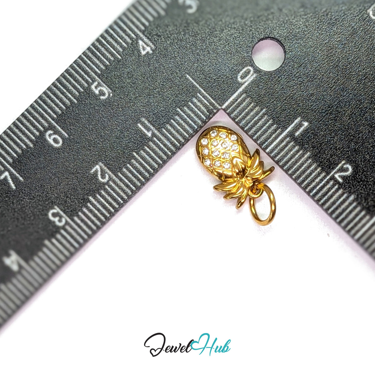 Crystal pineapple charm measured against a ruler at 9.8mm wide by 14.7mm tall - JewelHub