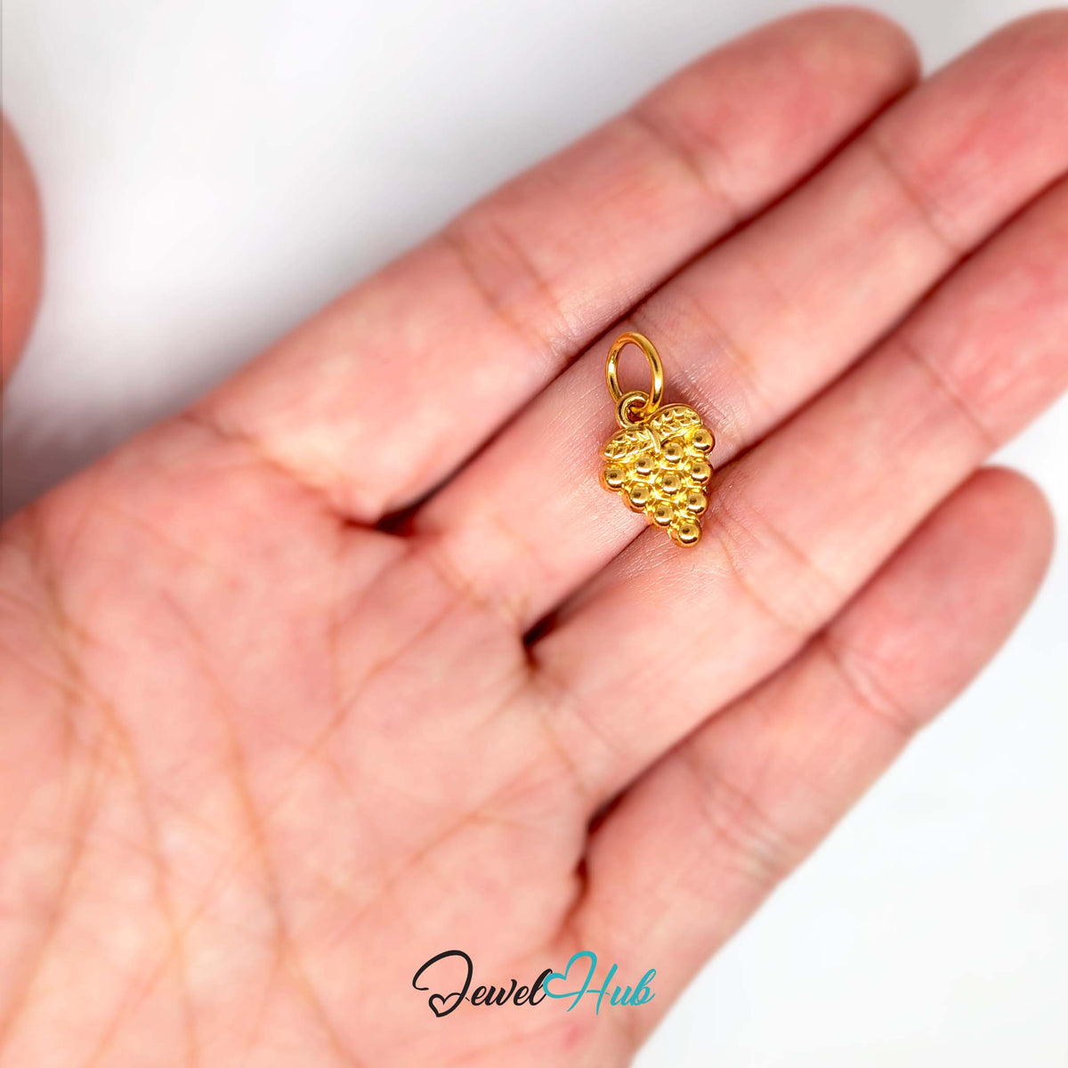 Beaded grape bunch charm held in a hand to show its size - JewelHub