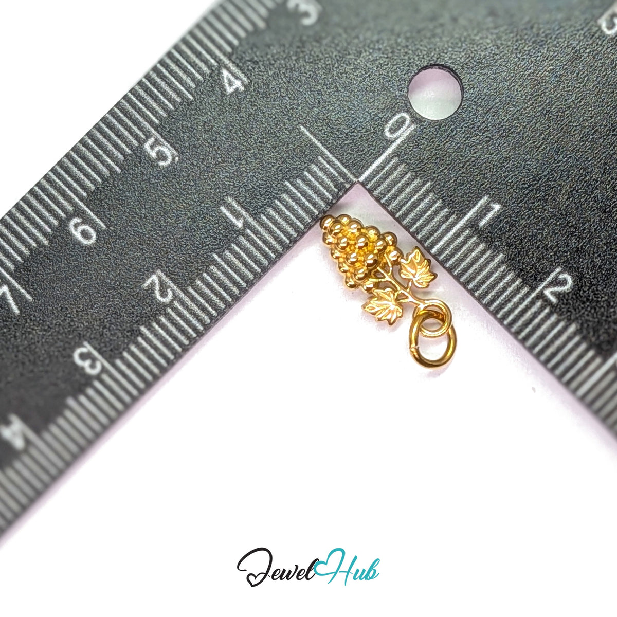 Grape bunch with leaves charm measured against a ruler at 8.6mm wide by 16.5mm tall - JewelHub